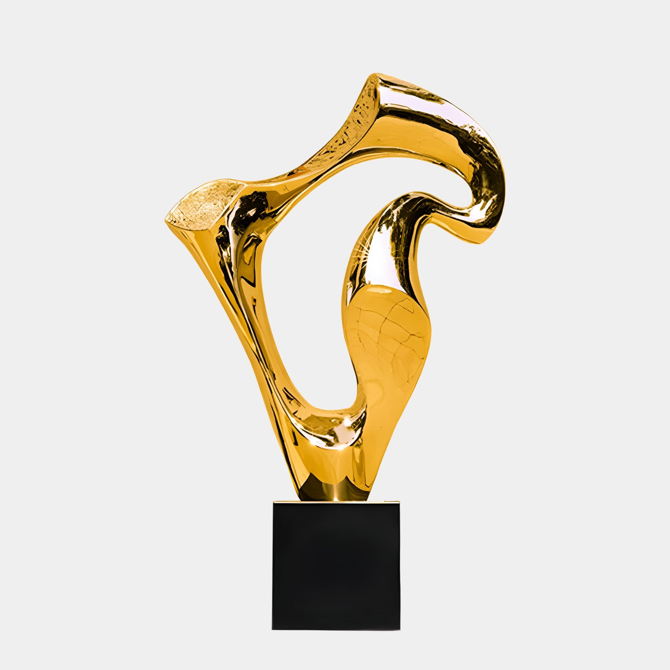 A golden abstract sculpture featuring a twisted, fluid design on a black pedestal.