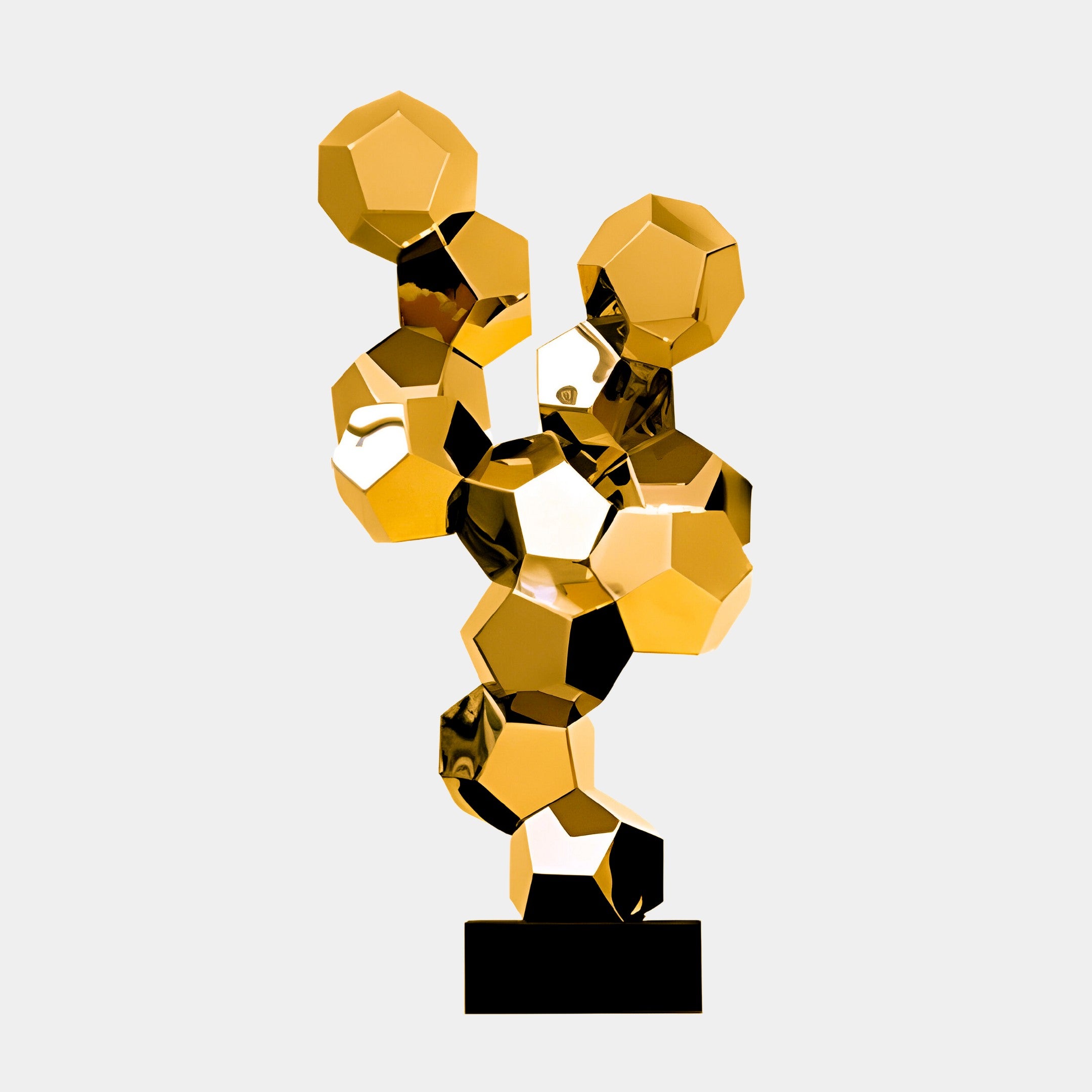 A gold geometric cluster sculpture made up of faceted polygons, placed on a black base.