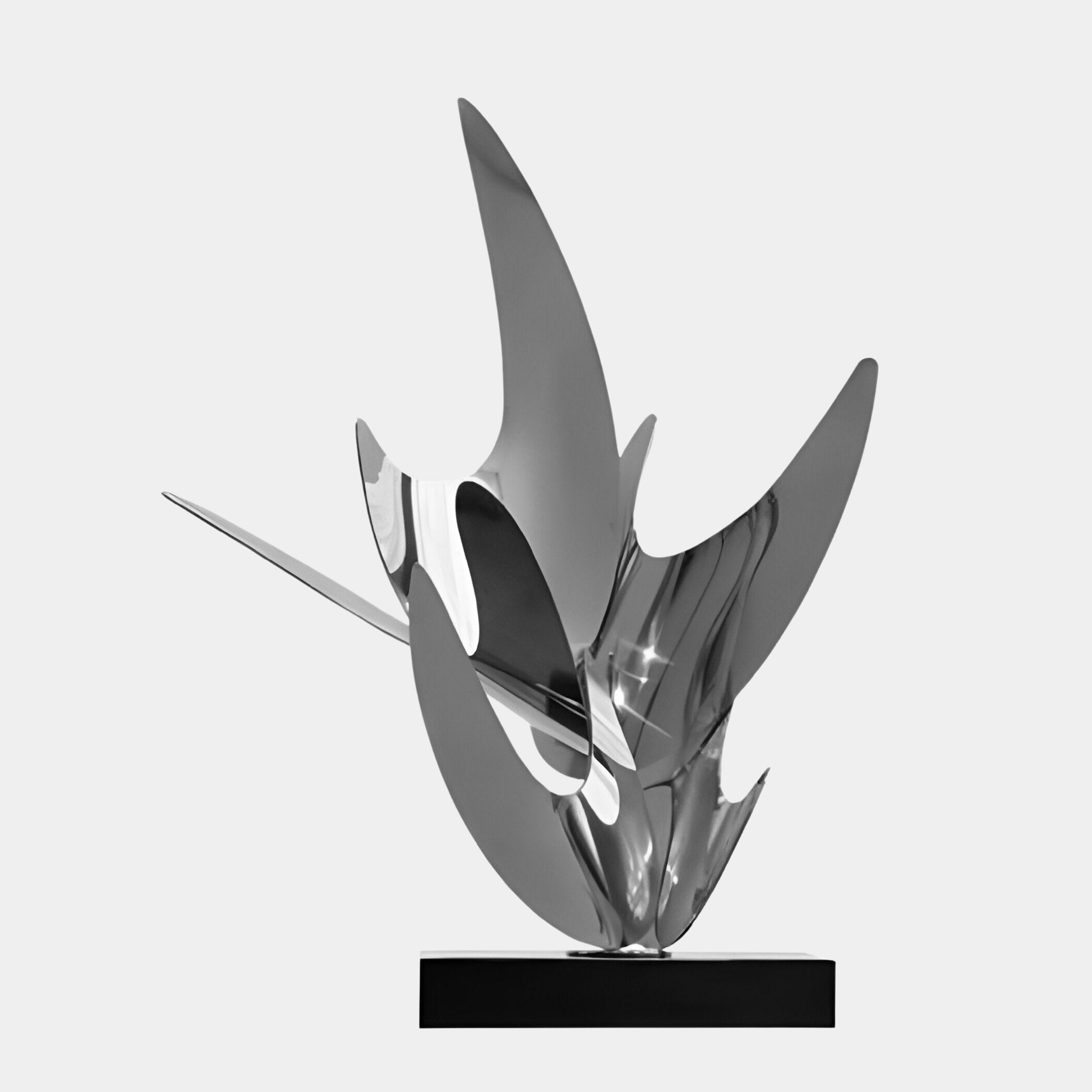 The 71cm Zephyr Silver Abstract Steel Sculpture by Giant Sculptures features a modern design with abstract forms that rise upwards reminiscent of wings or flames. It is set on a black base, with its polished silver surface elegantly reflecting light to enhance its dynamic appeal.