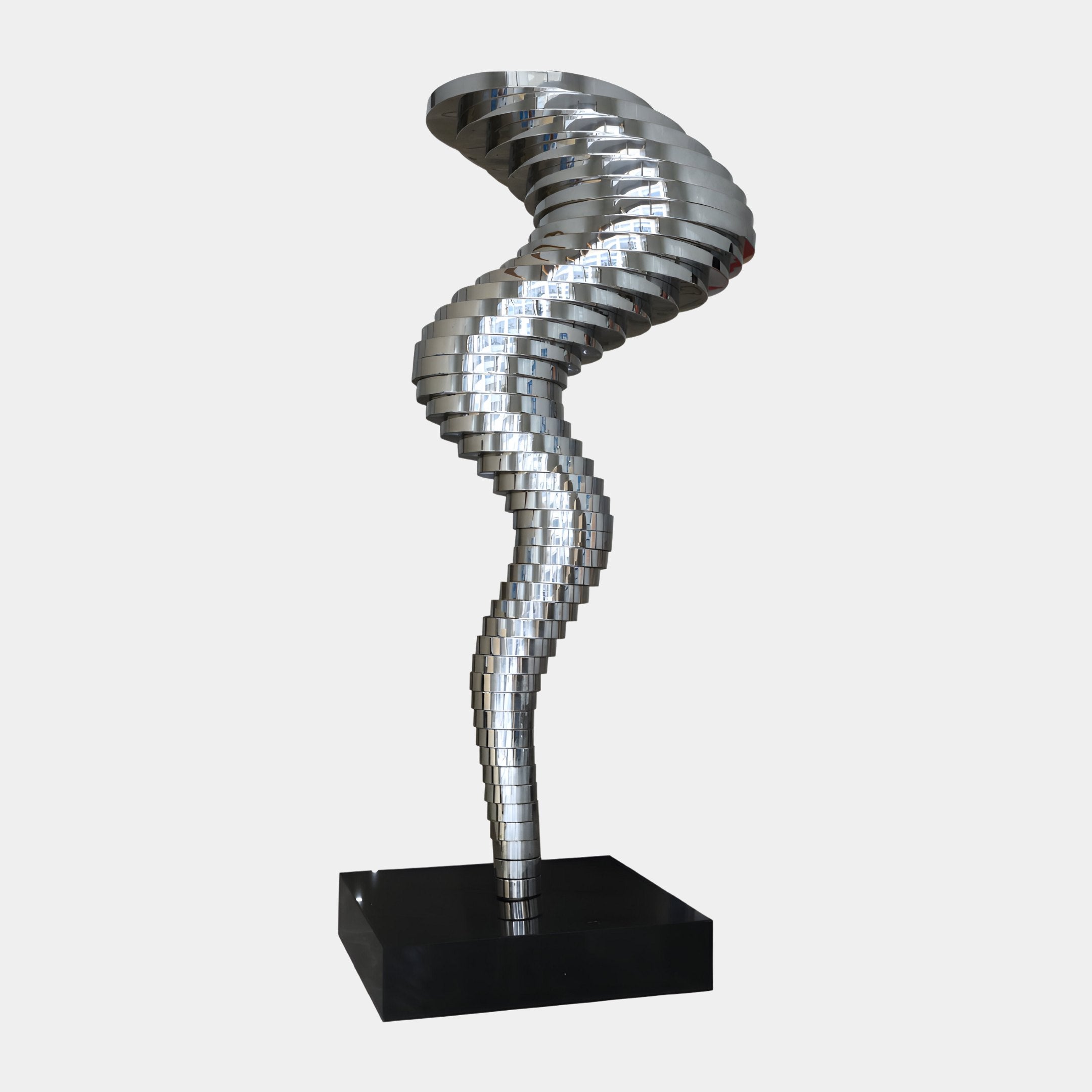 The Vortex III Abstract Steel Sculpture by Giant Sculptures is a modern embodiment of contemporary elegance. This 197cm masterpiece features stacked, twisting metallic discs that create a spiral shape, gracefully narrowing in the middle and expanding at both ends, all anchored on a sleek black rectangular base.