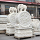 Two Elephant On Drum Marble Outdoor Sculptures by Giant Sculptures, featuring ornate elephants on intricately carved floral bases, are displayed outdoors on wooden pallets beside a tall metal fence and a building. Each sculpture stands 120cm tall.