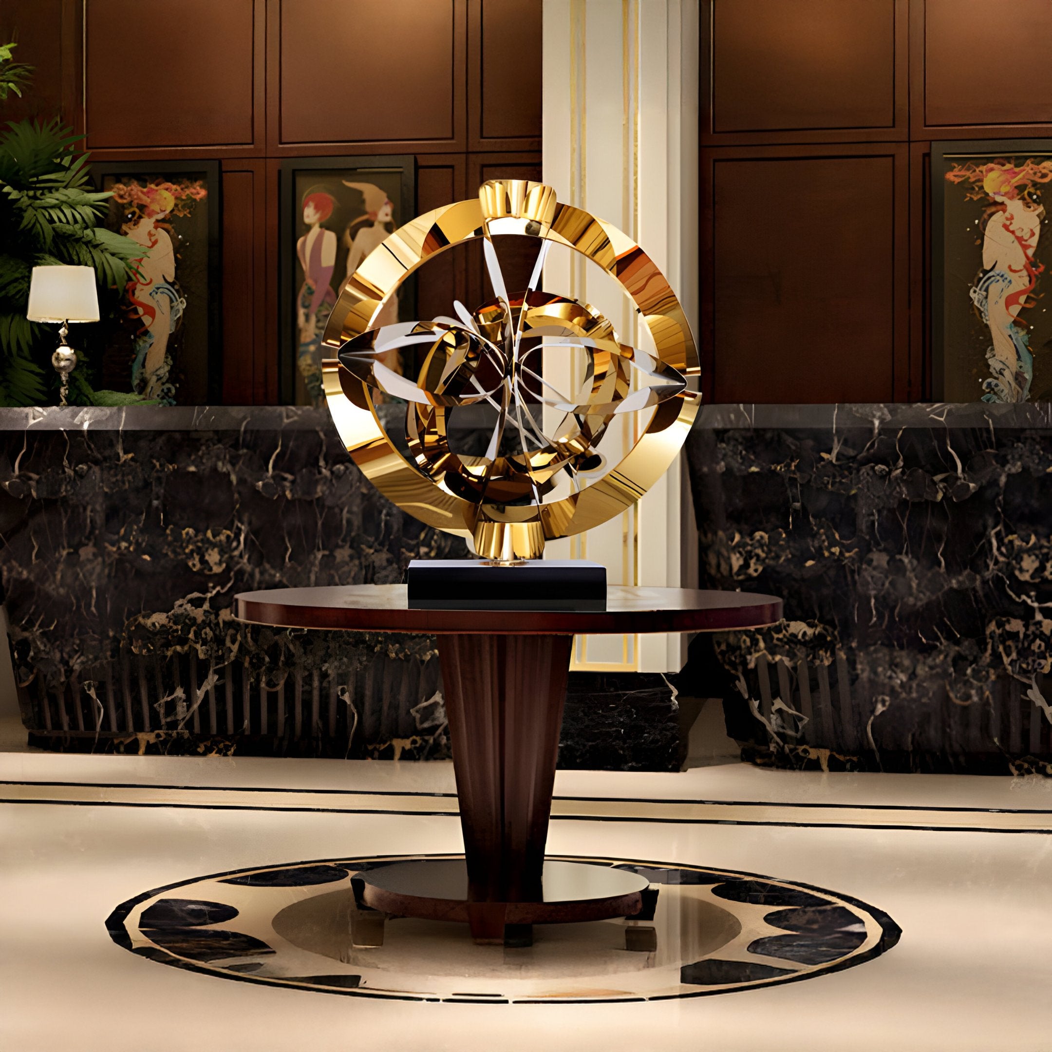 A luxurious hotel lobby exuding contemporary elegance features a round wooden table showcasing the Orbit Gold Geometric Steel Sculpture by Giant Sculptures. The background boasts dark marble walls adorned with geometric stainless steel accents, complemented by a lamp and decorative artwork.