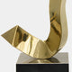 Discover the Sway Gold Abstract Steel Sculpture - 65cm by Giant Sculptures. This piece, consisting of shiny golden steel with smooth curves and angular edges, is mounted on a black square base. Its reflective surface elegantly captures light, creating dynamic highlights and shadows, making it an ideal addition to modern décor.