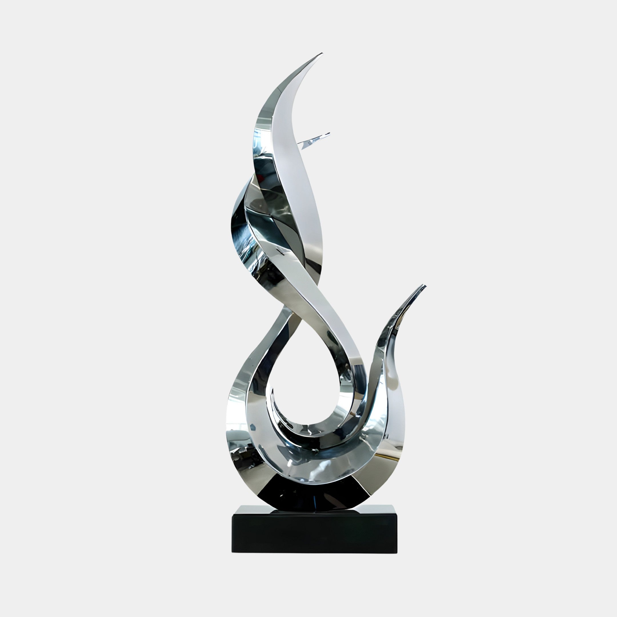 A silver abstract flame sculpture with smooth, curved lines on a black base.