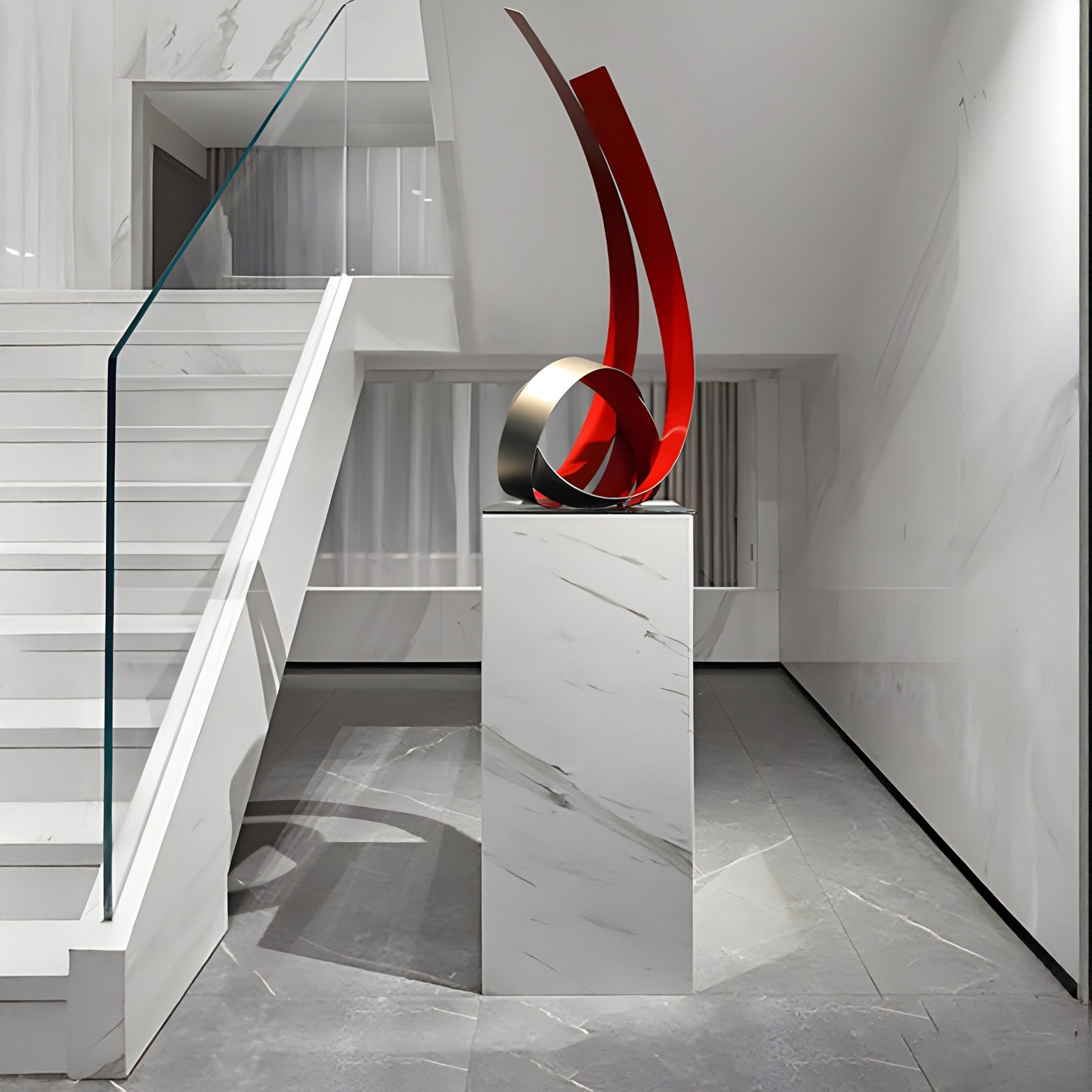 A modern hallway with white marble walls and floor showcases the Ribbon Red Abstract Steel Sculpture (73 cm) by Giant Sculptures, crafted from weather-resistant stainless steel, on a marble pedestal. A glass-railed staircase ascends on the left.