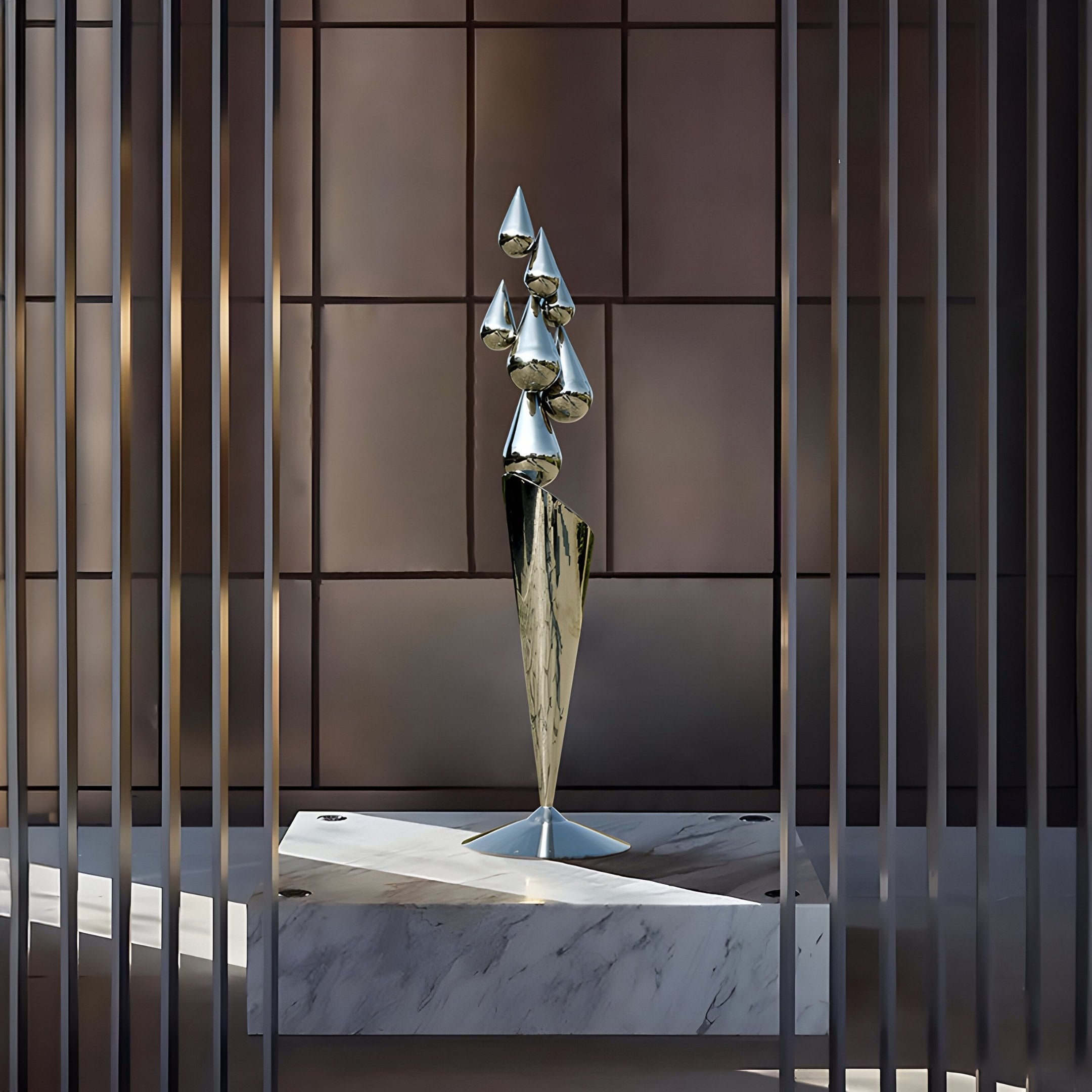 The 215cm Teardrop Abstract Steel Outdoor Sculpture by Giant Sculptures features elongated conical shapes on a marble pedestal. Set amidst vertical slats and a geometric-patterned wall, it creates a striking contrast between materials and forms.