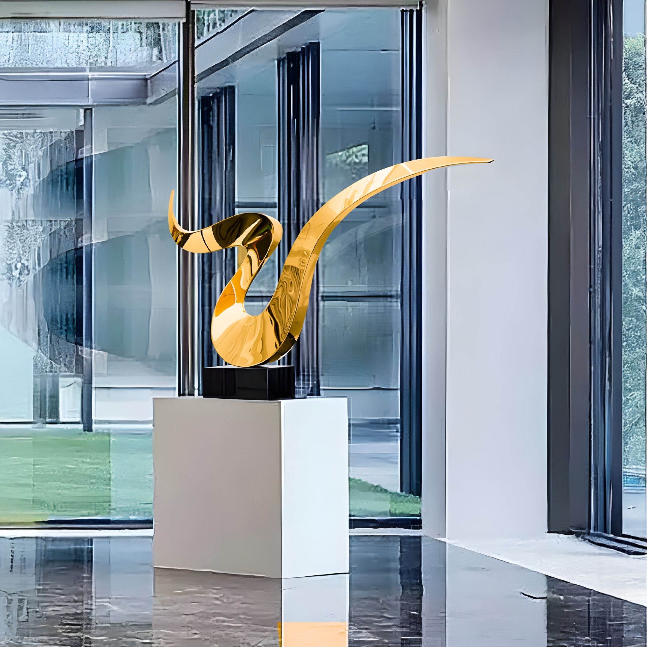 The sleek Whisper Gold Abstract Steel Sculpture by Giant Sculptures sits on a white pedestal, set in a modern glass-walled room with views of the surrounding greenery. Light dances off its glossy surface, creating a striking visual effect with its smooth, flowing design.