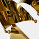 A close-up view of the gold sculpture, highlighting its reflective surface and smooth curves.