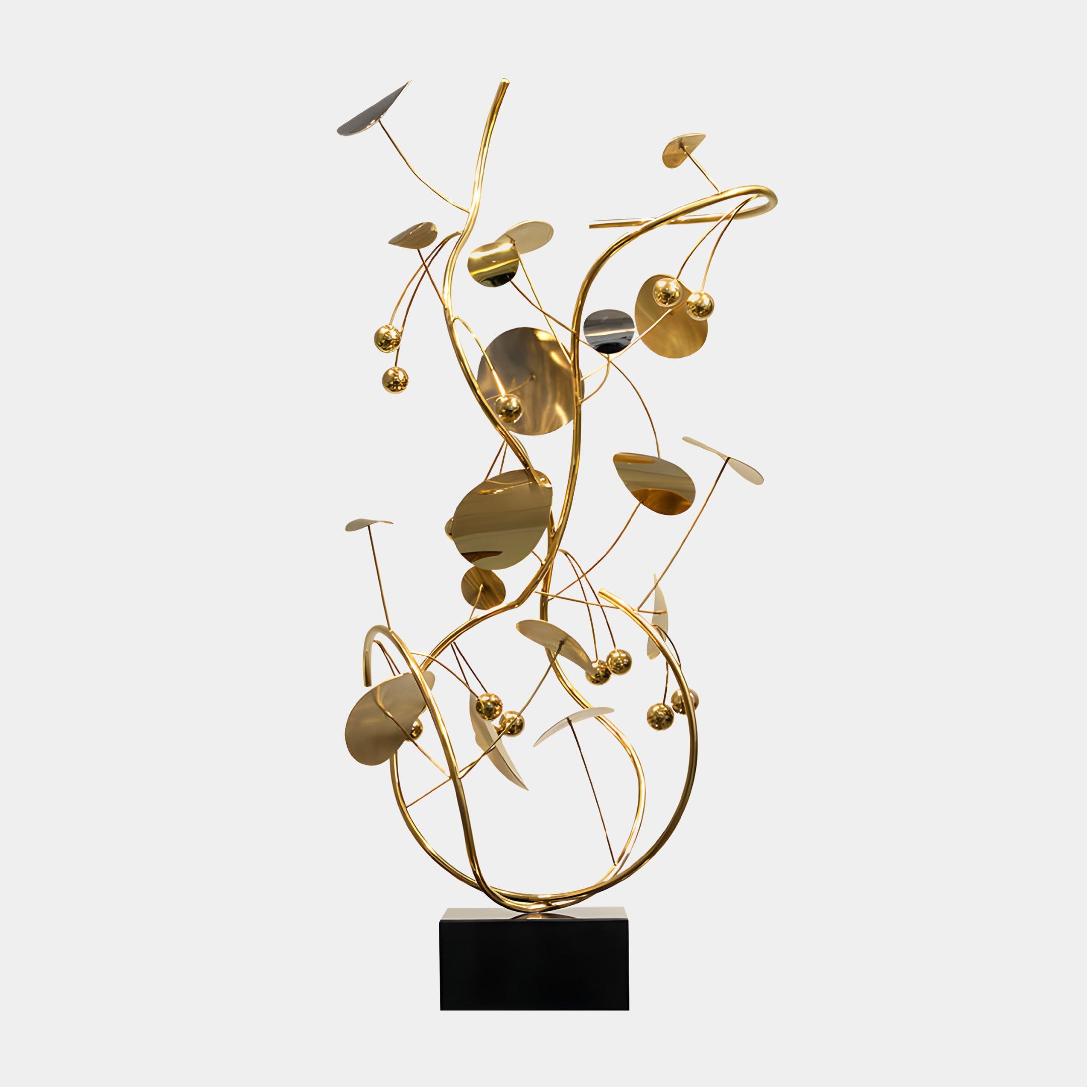 A gold abstract sculpture featuring rounded and curved forms on a black base.