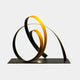 The "Ribbon Gold III Abstract Steel Sculpture - 75cm" by Giant Sculptures is a contemporary artwork featuring intertwined metallic loops in stainless steel and gold. These loops rest elegantly on a flat, dark base, creating a dynamic and refined contrast against the light gray background.