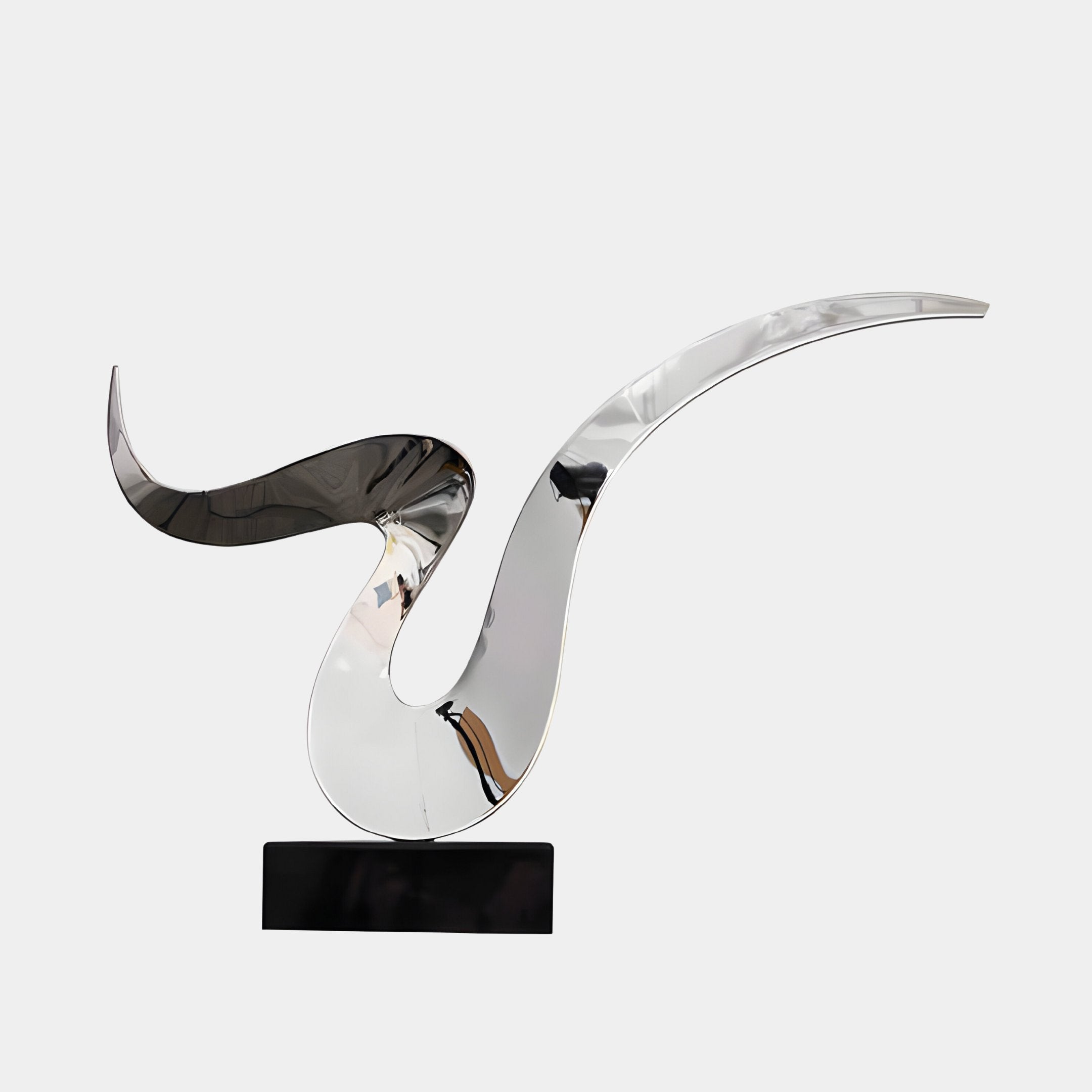 The Whisper Silver Abstract Steel Sculpture by Giant Sculptures is a sleek, modern design featuring shiny, curved metallic elements reminiscent of a flowing ribbon. Crafted from stainless steel, it sits gracefully on a rectangular black base against a plain white background.