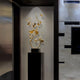 Gold sculpture displayed on a black stand against a contemporary interior setting.