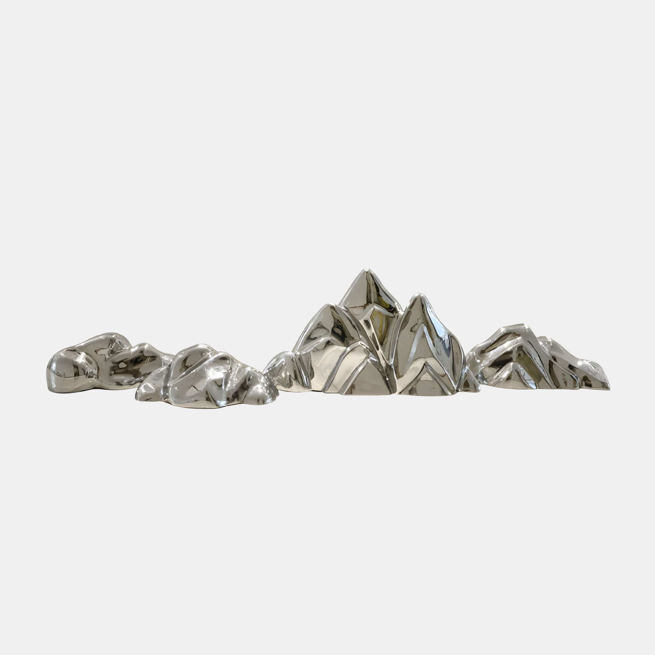 The Summit Abstract Steel Mountain Sculpture by Giant Sculptures is a collection of metallic, geometrically shaped artworks resembling abstract mountains, arranged on a plain background. Their reflective surfaces give a sleek and modern look.