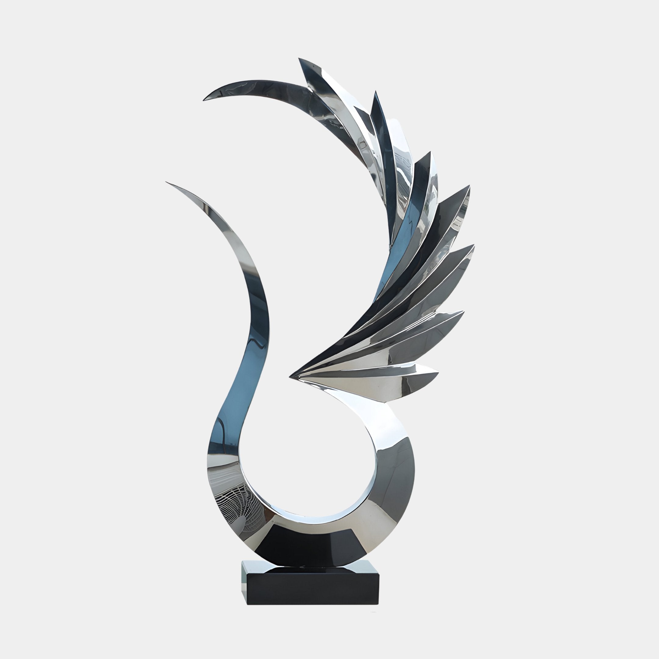 The "Wings Of Light Silver Abstract Steel Sculpture - 102cm" by Giant Sculptures showcases flowing modern sophistication with its silver design. It features a curved base leading to multiple wing-like elements that extend upward, embodying a sense of movement and contemporary elegance as it rests on a minimalist black pedestal.