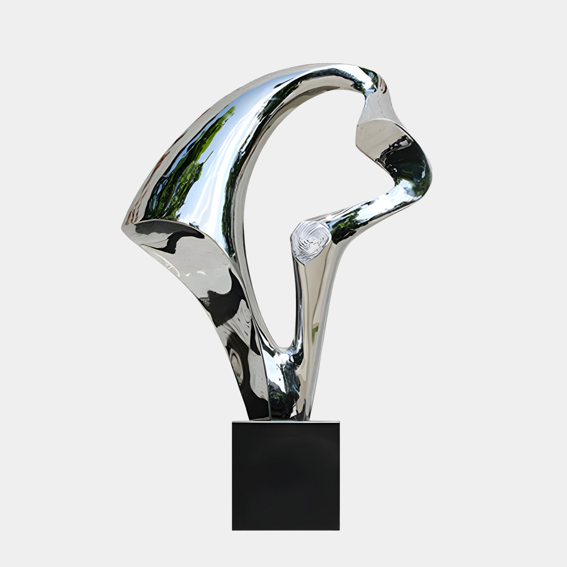 A silver abstract sculpture with curved, reflective surfaces on a black base.