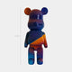 The 50cm limited edition Midnight Sunset Bear Sculpture by Giant Sculptures, designed by Adam Illes, is shaped like a bear with large ears and features galaxy-like gradients of blue, purple, orange, and red.