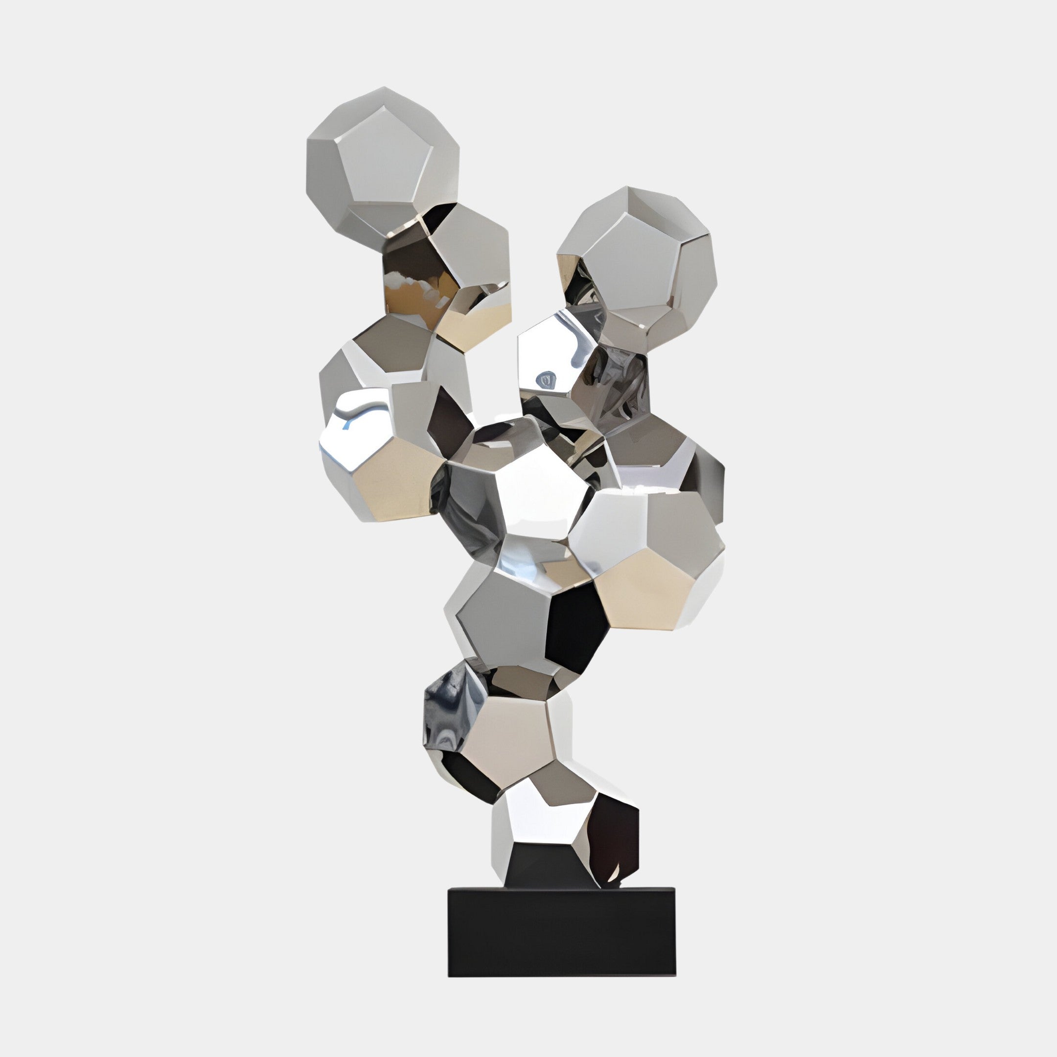 A silver geometric cluster sculpture made up of multiple faceted shapes, mounted on a black base.