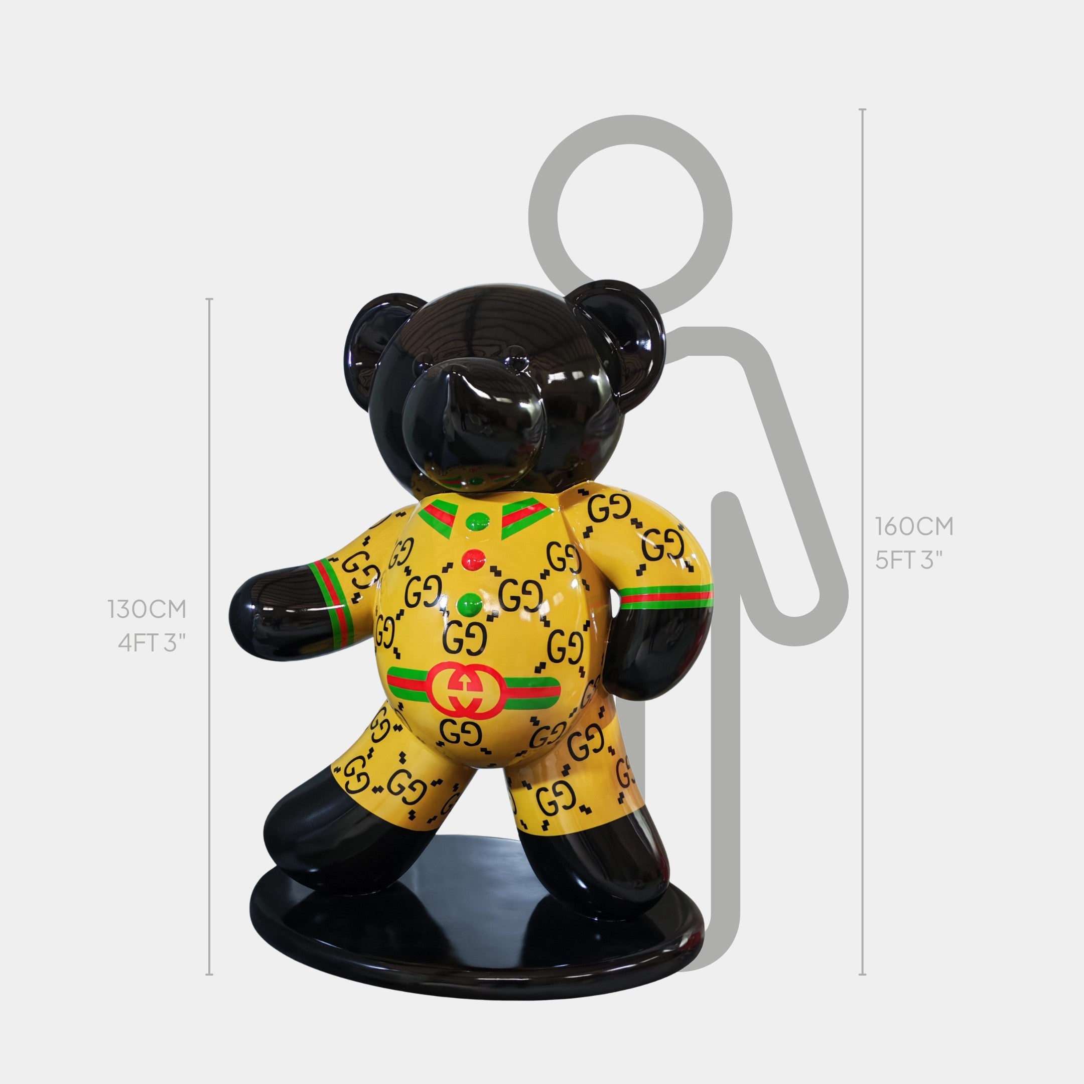 The Gacko Gucci Bear Sculpture - 130cm by Giant Sculptures features a glossy black bear in a yellow pop art outfit, shown beside a 160 cm gray silhouette for scale—an eye-catching luxury decor piece for any space.