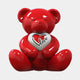 The Gacko Love Bear Sculpture - 80cm by Giant Sculptures features a shiny red bear inspired by Pop Art, holding a white heart with a red heart and "Love" in black cursive, sitting upright against a plain white background.