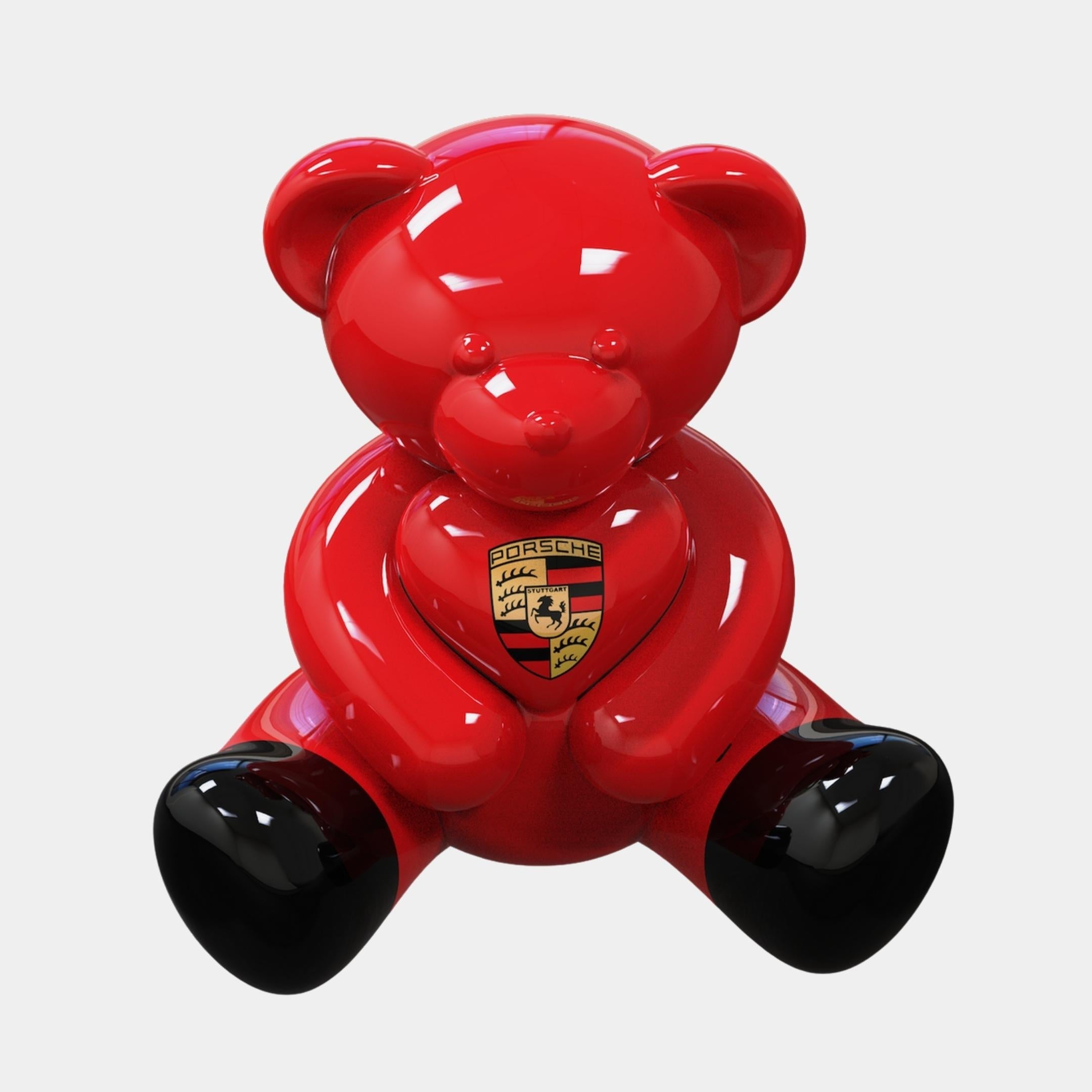 Three-quarter view of the 80cm Gacko Porsche Love Bear Sculpture by Giant Sculptures, showing the mirror-wet red lacquer across the rounded ears and limbs and the crested heart held to the chest.