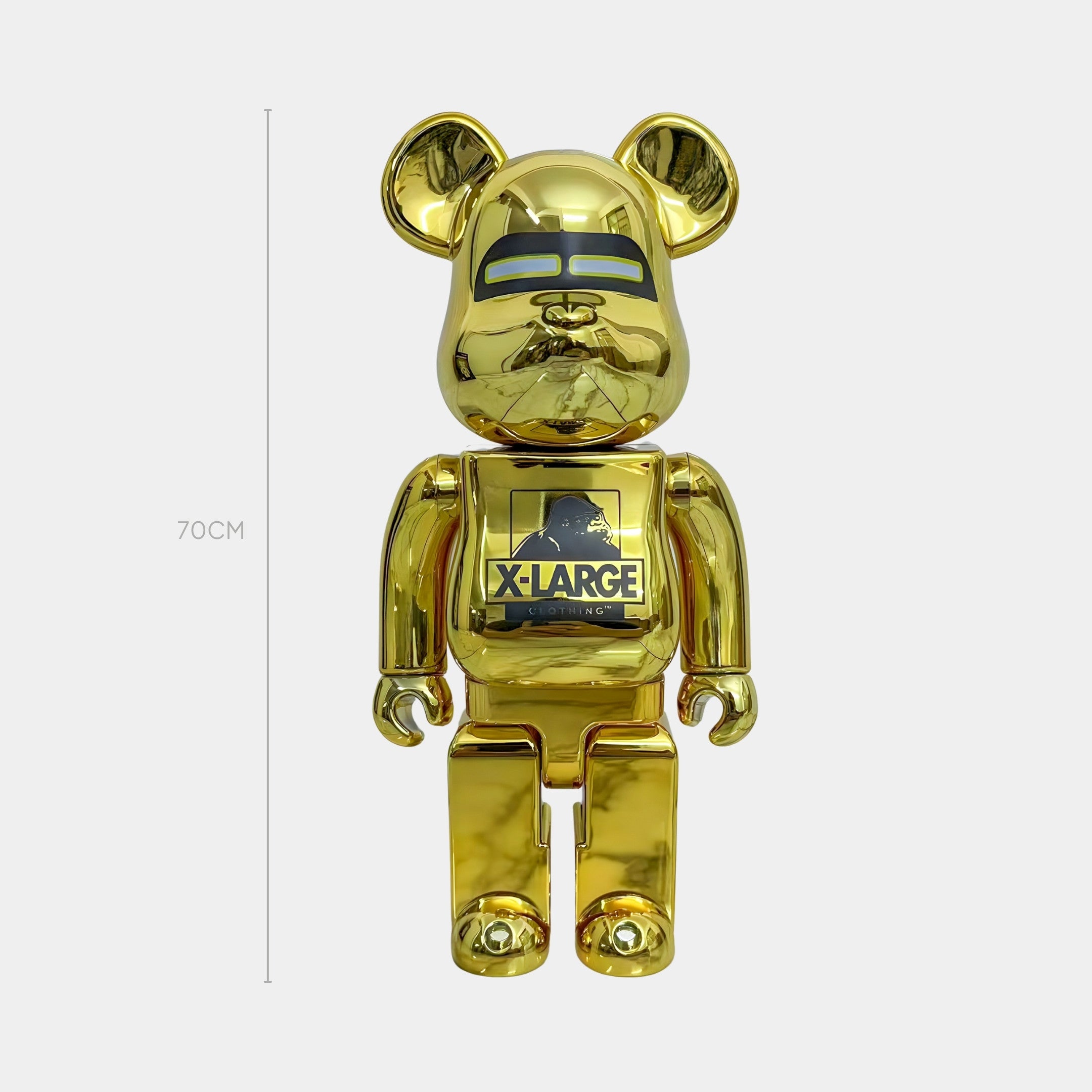 The Gorilla Crest Gold Bear Sculpture - 70cm by Giant Sculptures stands upright with the Gorilla Crest on its chest. A measurement line shows its 70cm tall, and the background is plain white.