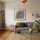 Tracera Stone Grey Line Textured Abstract Framed Wall Art by Giant Sculptures displayed in a living room above a grey sofa, showing its charcoal horizontal lines and matte black frame.