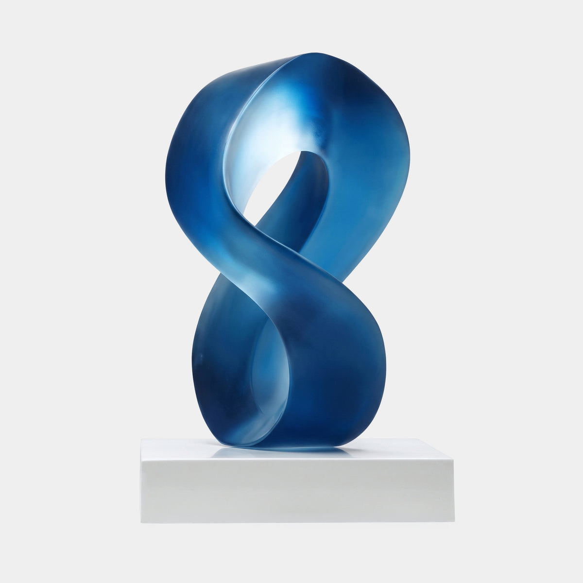 Blue Crossed Loop on Marble Resin Sculpture - 42cm, a twisting figure-eight band in frosted sapphire blue on a white marble base, shown against a plain light background.