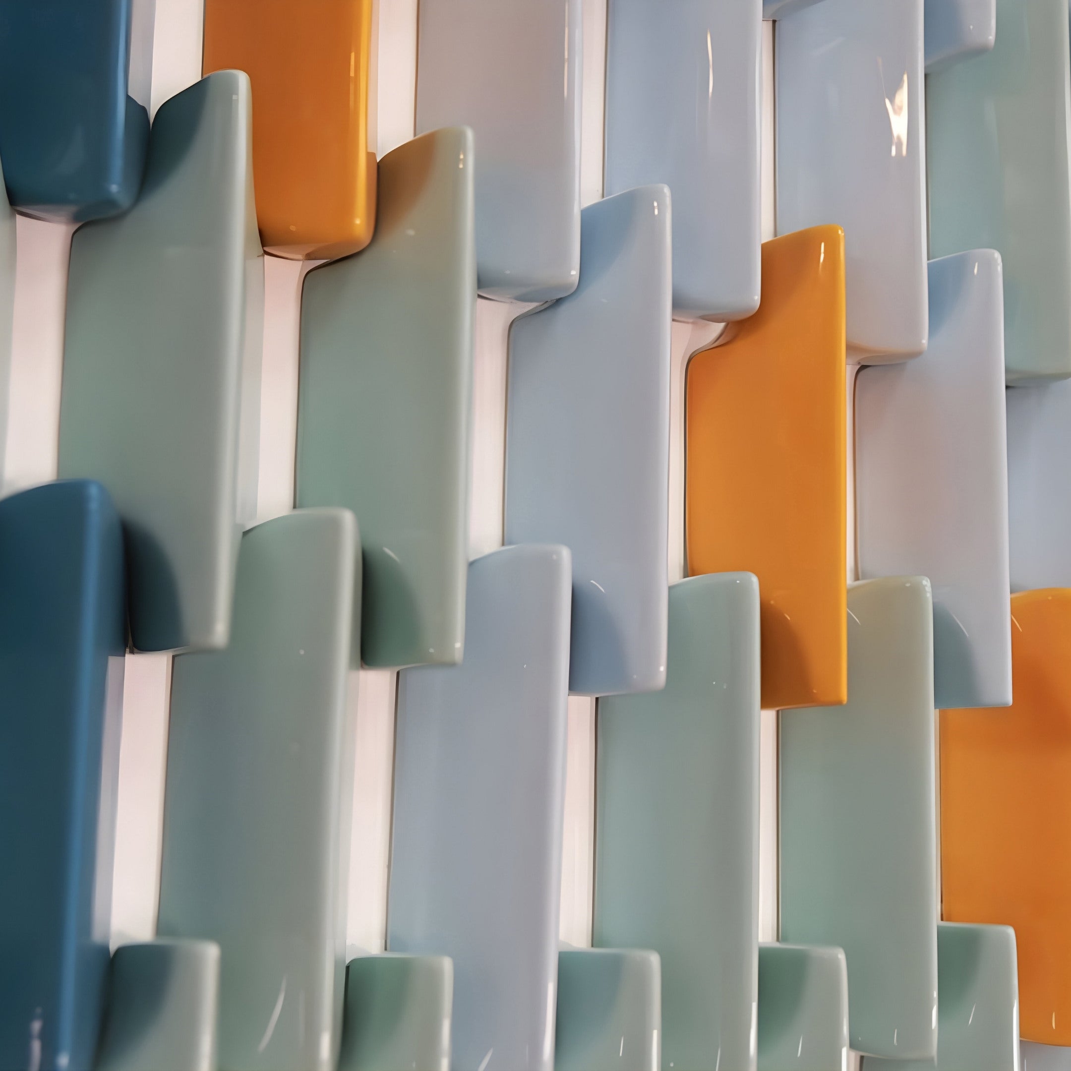 Close-up of the Artevo 3D Ceramic Wall Art by Giant Sculptures, featuring interlocking tiles in blue, aqua, gray, and yellow. The glossy finish with a wavy pattern adds an abstract touch to modern interiors.