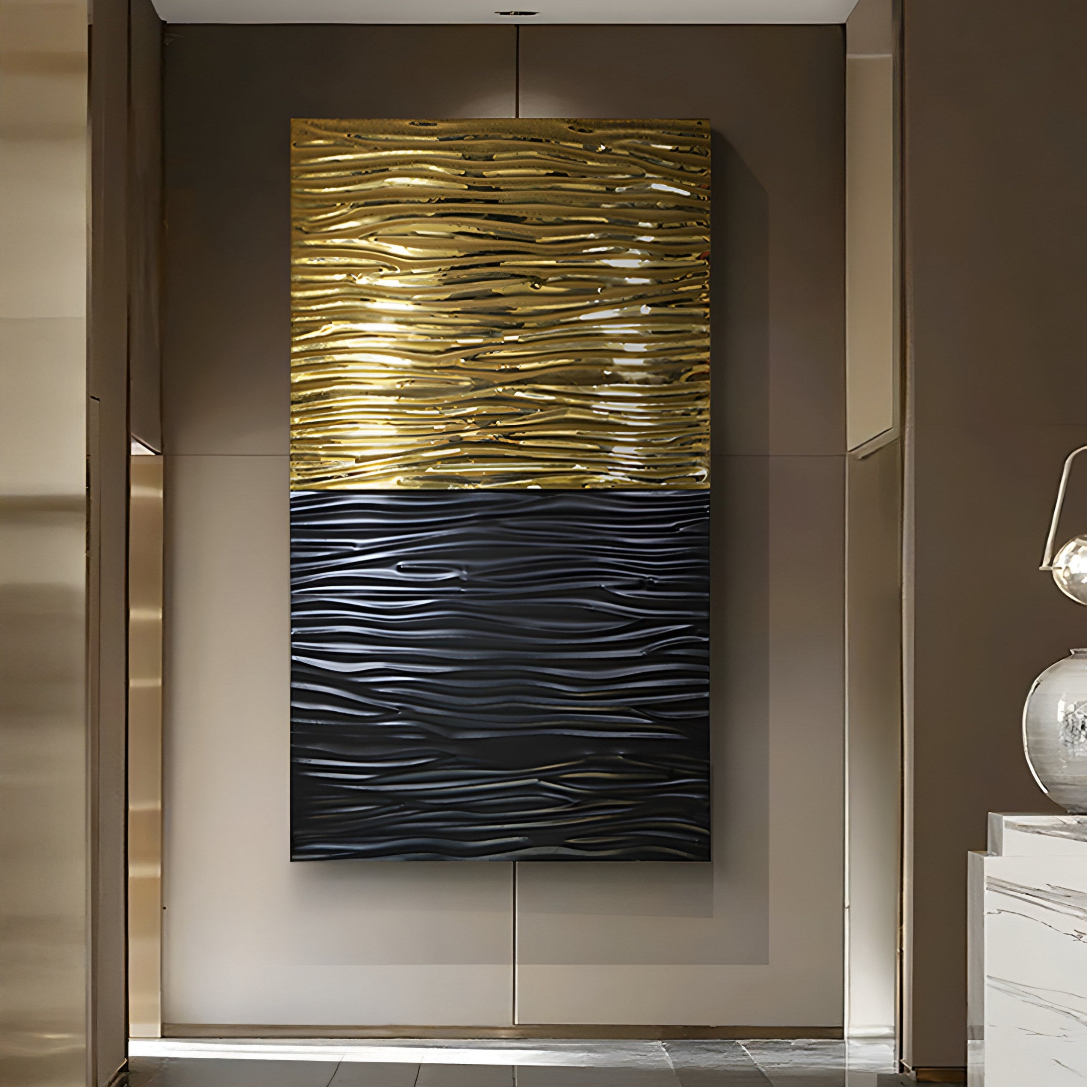 The Ripple Dual-Tone Black & Gold Textured Wall Art by Giant Sculptures adorns the wall with two stainless steel panels. The gold top and black bottom, both wavy in texture, enrich the minimalistic charm of a modern living room.