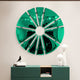 The Halo Emerald Segment Circle 3D Metal Wall Art by Giant Sculptures decoratively adorns a light wall above a modern teal cabinet, which displays a black bird figurine, stacked books, and two white spherical lamps.