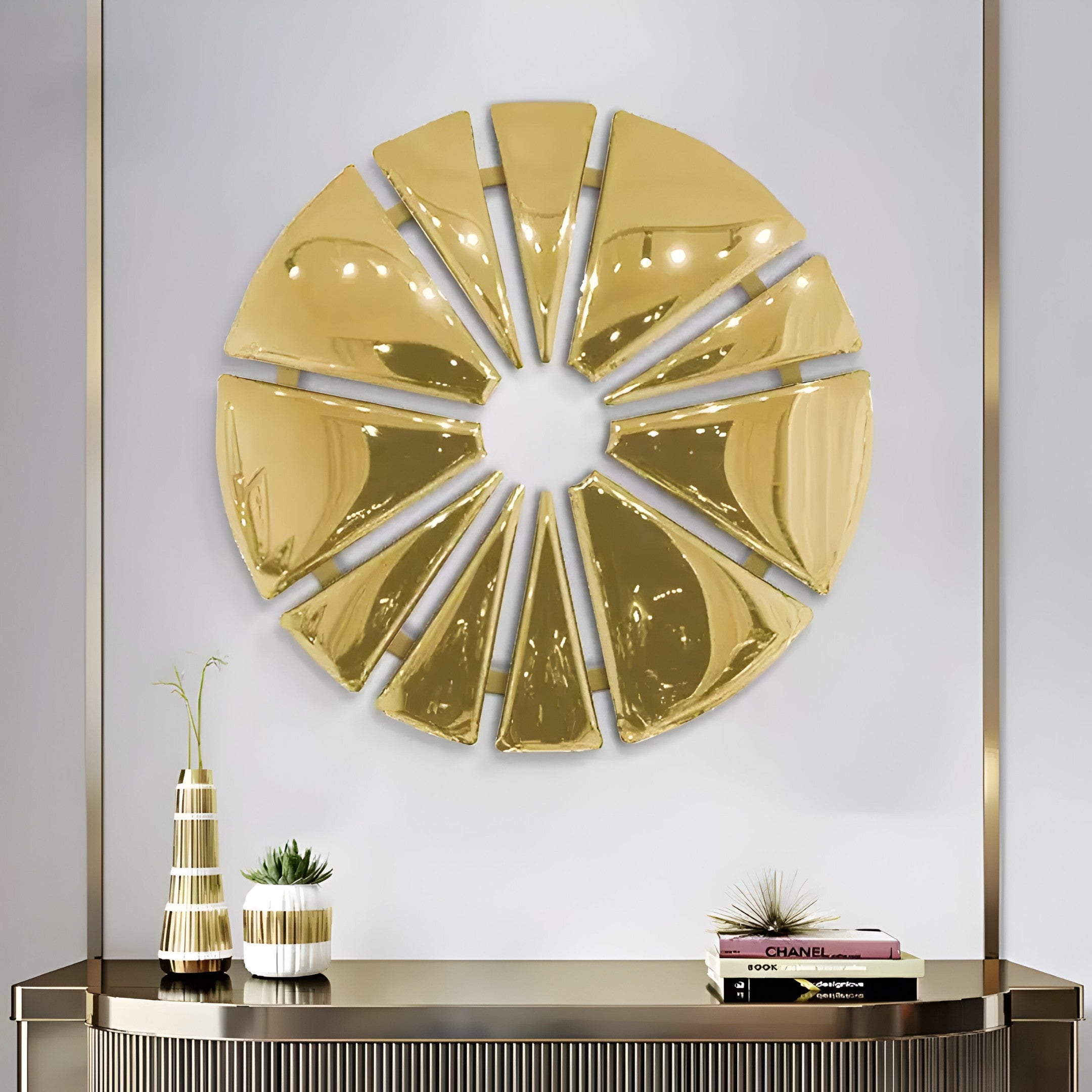 The Halo Gold Segment Circle 3D Metal Wall Art by Giant Sculptures features golden geometric shapes in a circle on the wall. Below, a console table with a vase and books complements the design, creating an elegant display with a neutral palette and metallic accents.