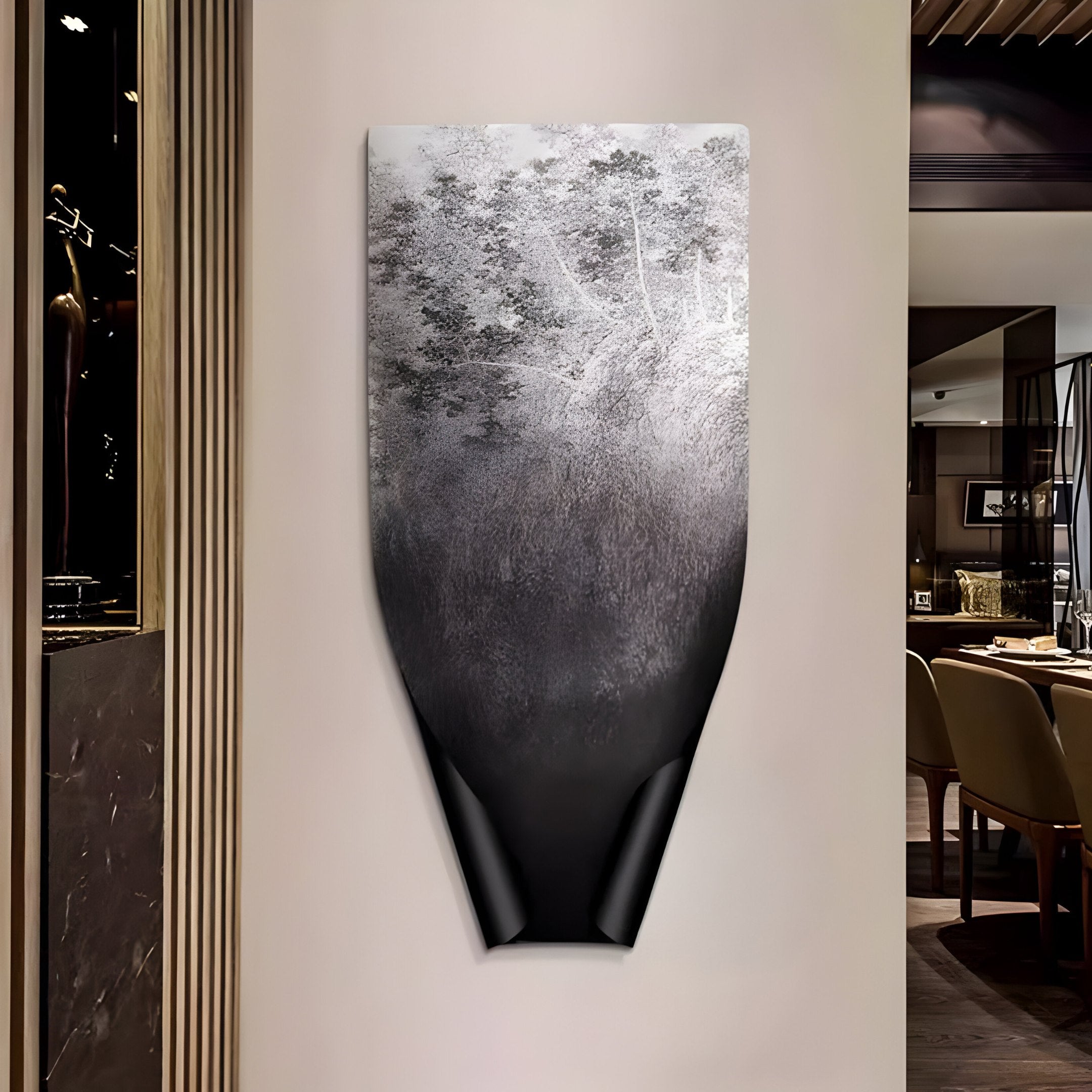 The Echo Forest Textured Abstract Panel Metal Etched 3D Wall Art by Giant Sculptures, with its black and gray textures, reflects forest silhouettes and mist. Mounted in a modern dining area with soft lighting and wooden chairs, it adds depth to the ambiance.