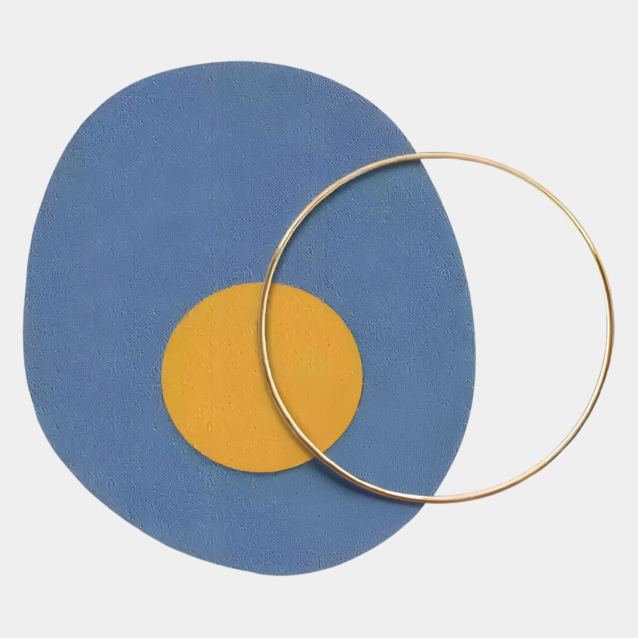 A Nordic-minimalist abstract by Giant Sculptures, the Solaro Radiant Blue & Yellow Round Mural Wall Art features a textured blue oval and yellow circle overlapped by a metallic ring on a crisp white background.