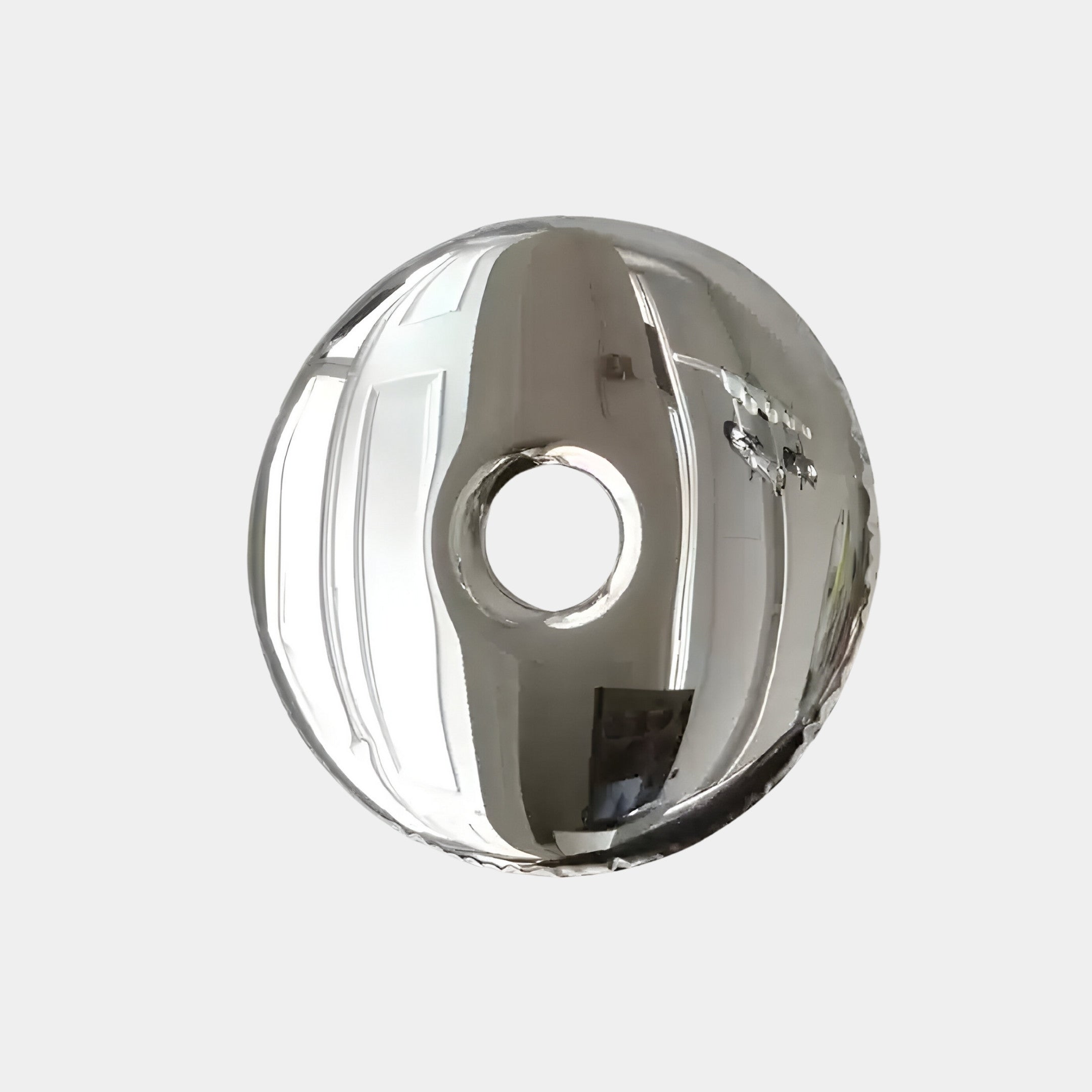 The Auro Chrome Round Gloss Metal 3D Wall Art by Giant Sculptures is a shiny, metallic, donut-shaped piece with a reflective chrome finish that captures its surroundings, including doors and walls, making it an intriguing addition to any space.