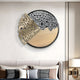 The Aurelio Left Metallic Layered Textured Round Wall Art from Giant Sculptures is placed above a gray sofa. This modern piece features a gold abstract textured section and a black-and-white speckled half-circle. Cushions decorate the sofa below.