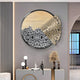 A modern living room features the Aurelio Right Metallic Layered Textured Wall Art by Giant Sculptures, showcasing abstract patterns in textured gray with a metallic gold fan shape. Below, a minimalist sideboard holds decorative sculptures, vases, and dried grasses.