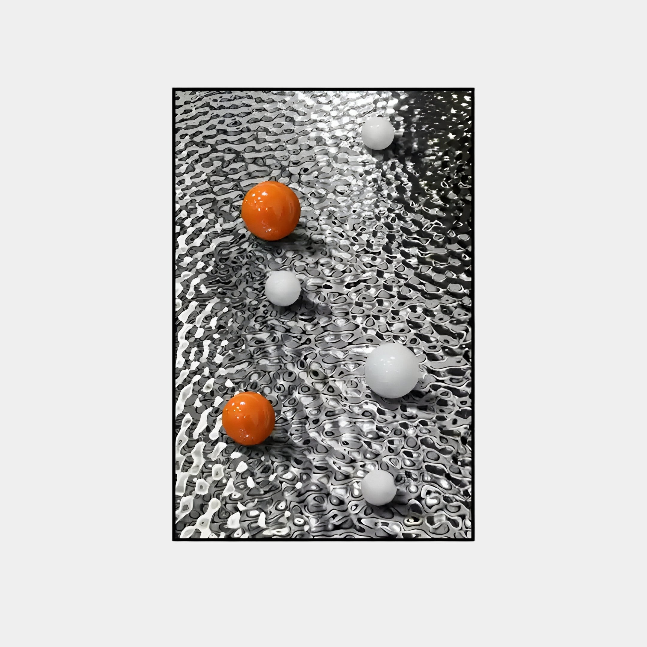 The Luminosa Orange & White Orb Textured Metal Wall Art from Giant Sculptures features a silver, textured metal design with five glossy spheres—three white and two orange—arranged diagonally. The spheres reflect light, adding a dynamic touch ideal for contemporary interiors.