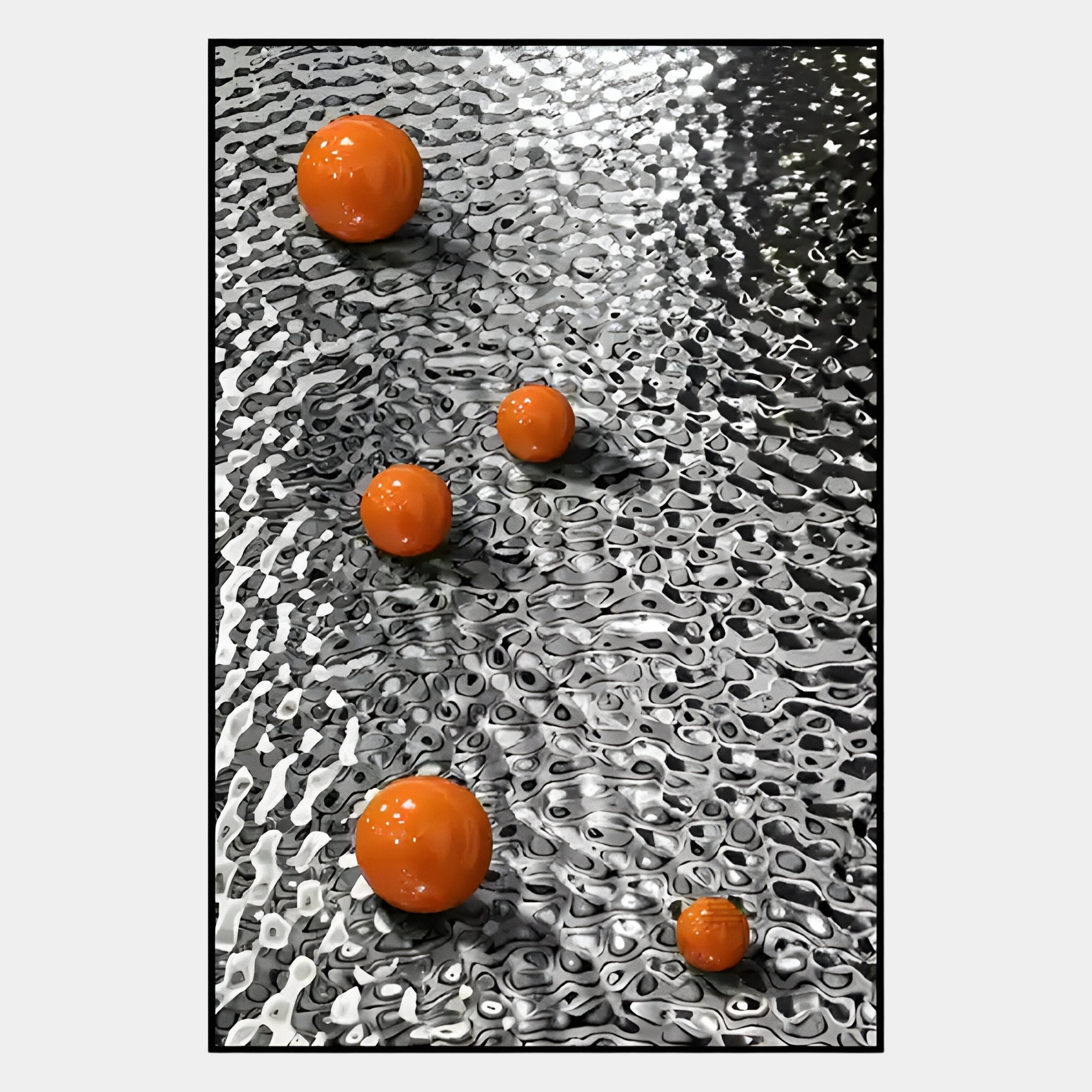 The Luminosa Orange Orb Textured Metal Wall Art by Giant Sculptures features four shiny orange orbs of varying sizes on a reflective silver surface, ideal for contemporary design and textured metal wall art displays.
