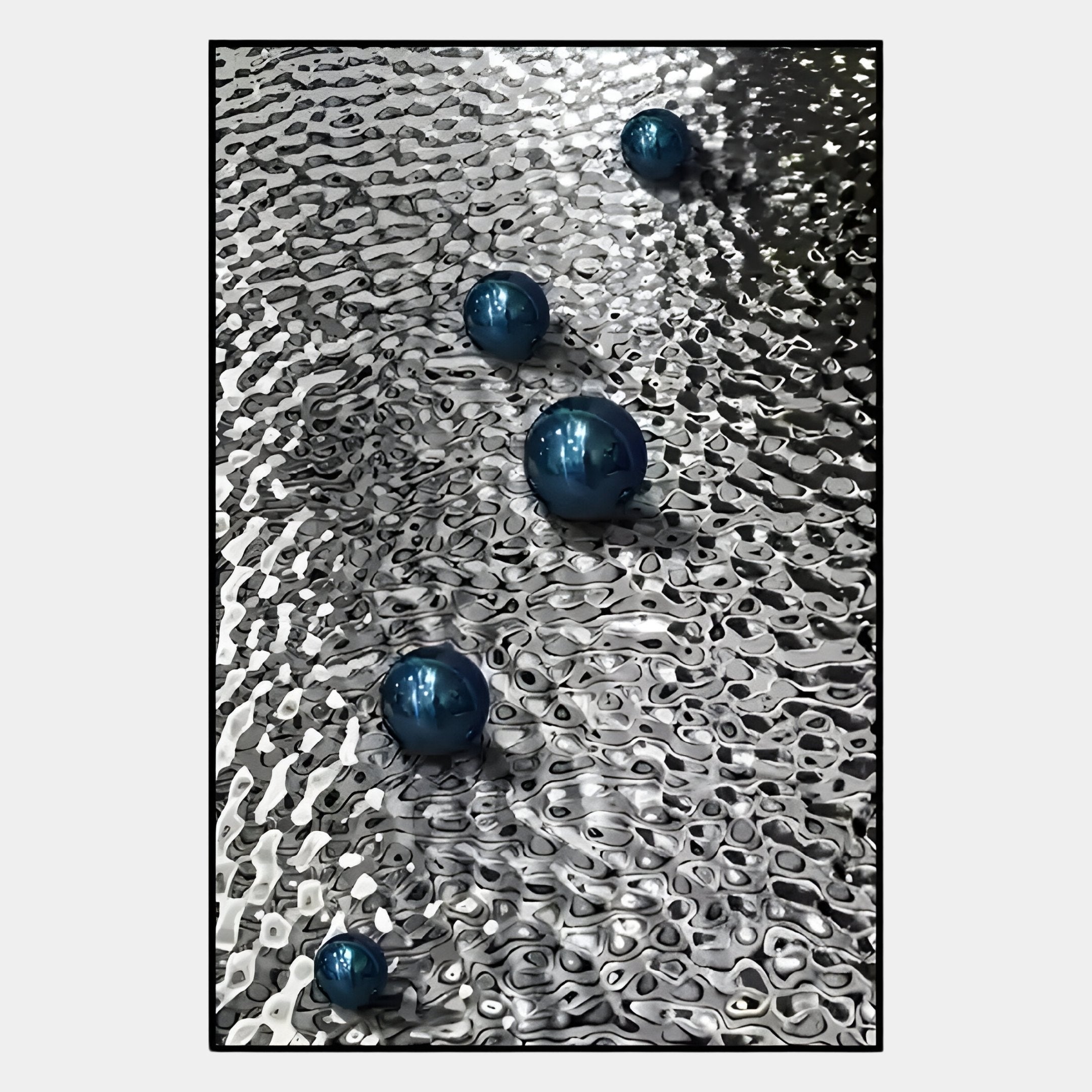 Five blue metallic spheres rest on a wavy silver surface, creating abstract reflections. The Luminosa Blue Orb Textured Metal Wall Art by Giant Sculptures adds a modern, striking touch to contemporary interiors with its unique and stylish design.