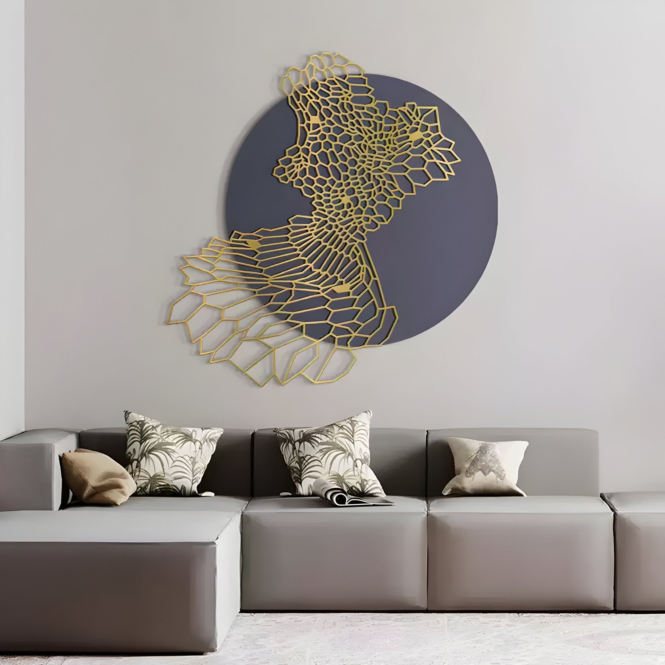 A modern living room features a gray sectional with patterned cushions, complemented by the Cellura Deep Purple Geometric Layered Gold Wired Metal Wall Art by Giant Sculptures, showcasing an intricate design over a dark circular backdrop for a striking focal point.