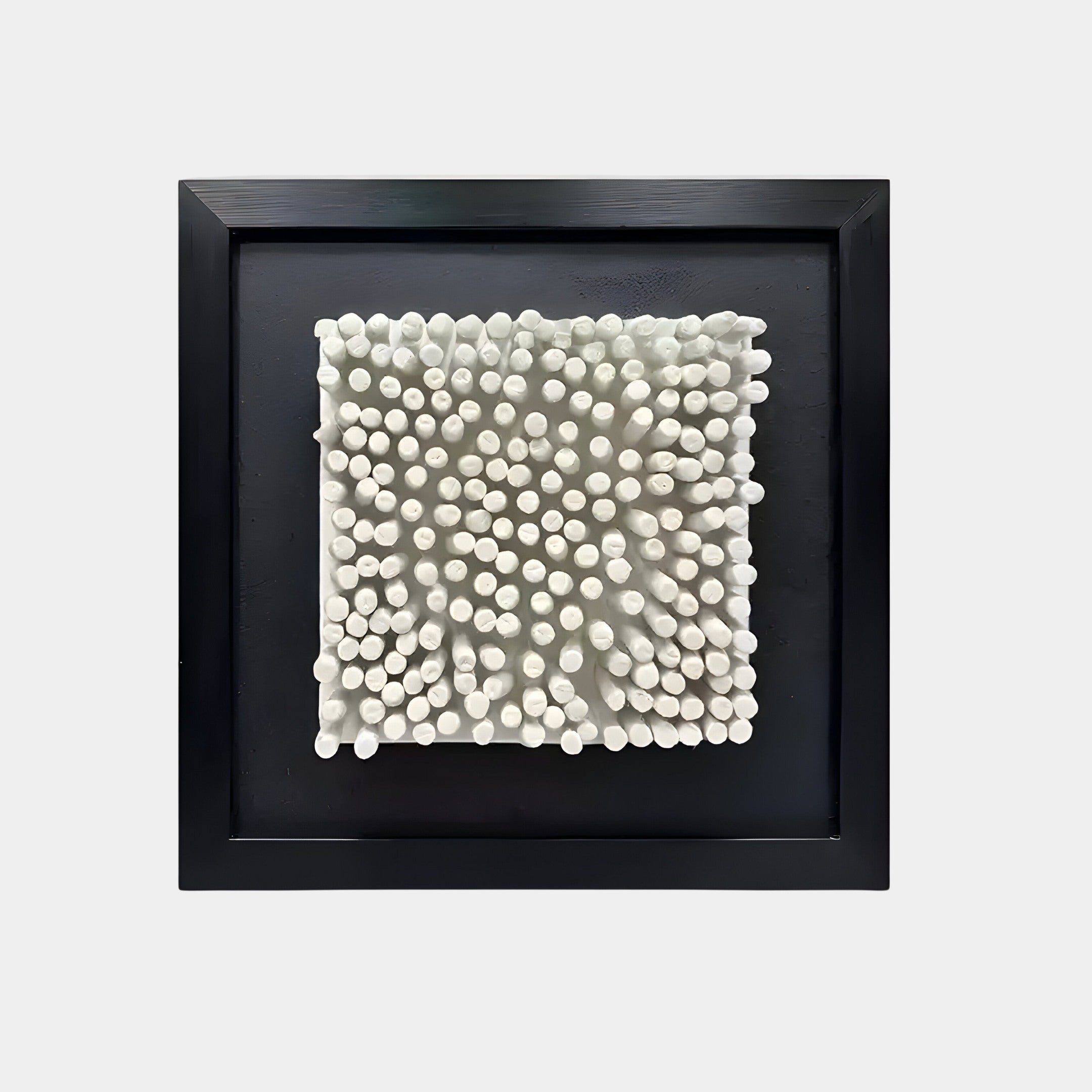 Abstract 3D wall sculpture with white textured ceramic rods arranged on a square black frame. A modern, sculptural art piece for contemporary interiors.