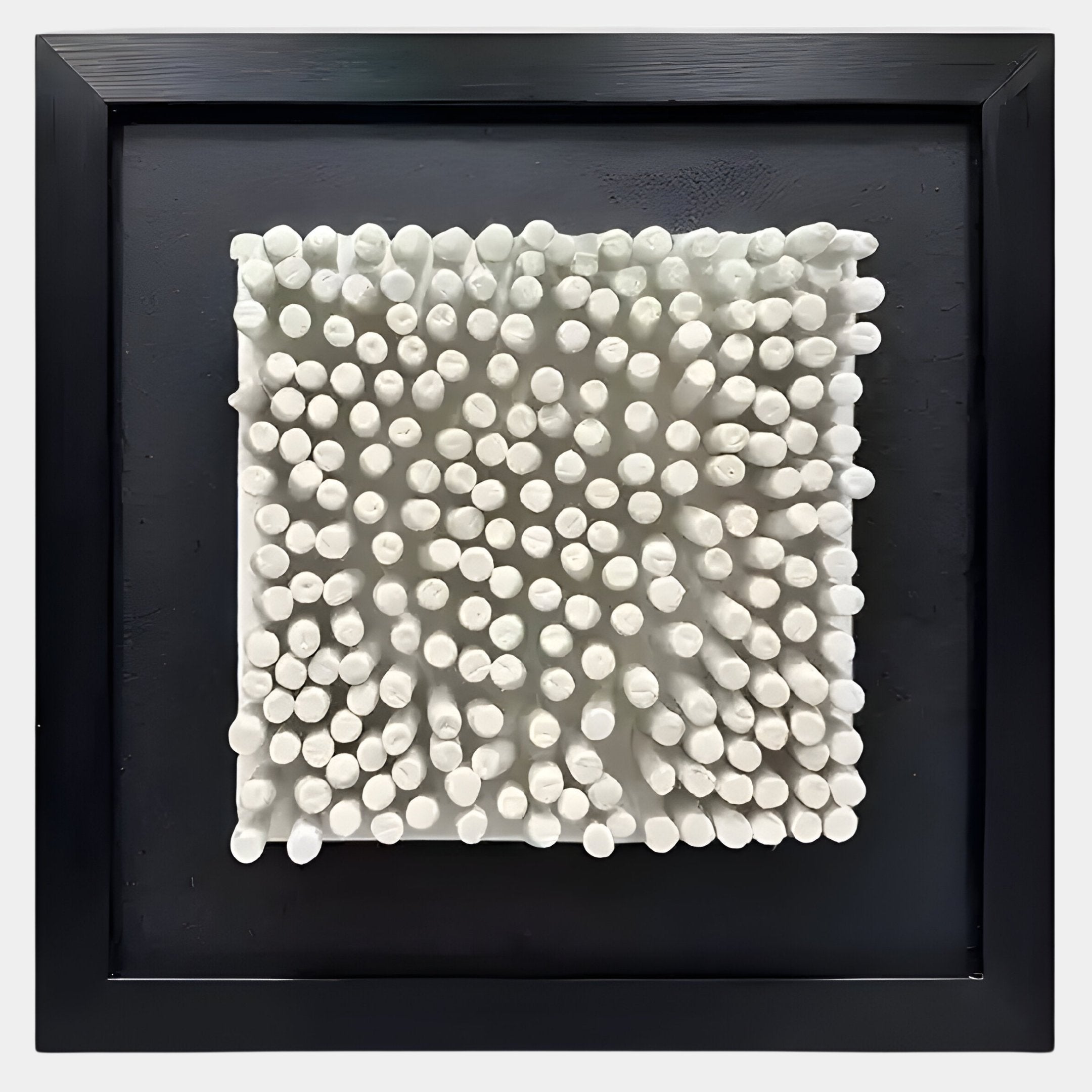 The Harmonia 3D Ceramic Grid Wall Sculpture With Black Frame by Giant Sculptures features a square white ceramic surface with clustered rounded cylindrical protrusions, arranged in a modern grid—ideal for contemporary interiors.