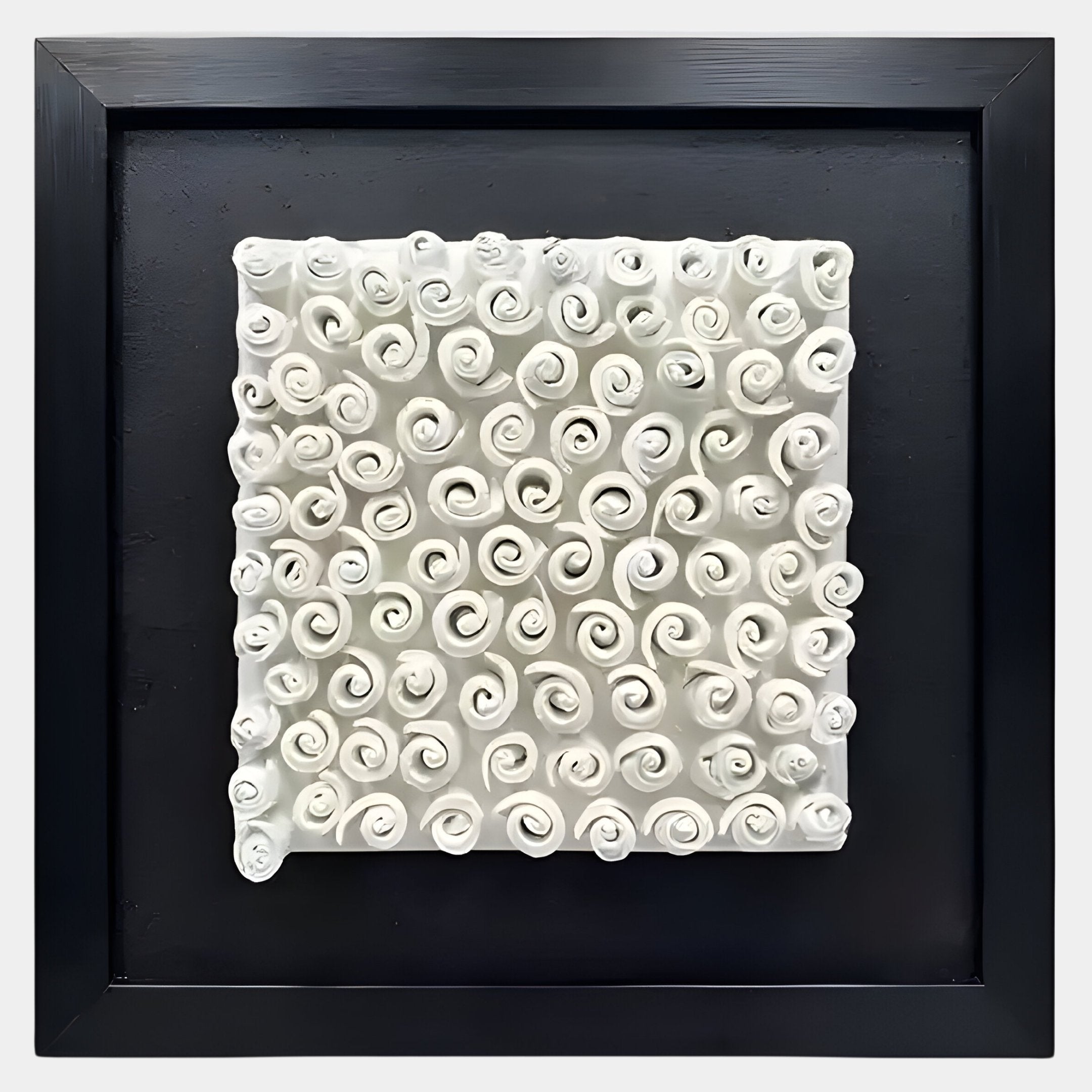 The Harmonia 3D Spiral Wall Sculpture by Giant Sculptures features numerous small, rolled spirals in textured white ceramic, arranged in a grid and displayed within a square black frame against a smooth black background.