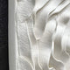 Close-up of the Harmonia 3D Ceramic Rose Sculpture by Giant Sculptures, featuring wavy, layered rose-inspired patterns in white. The black background contrasts with the sculpted texture, adding depth to this modern artistic masterpiece.