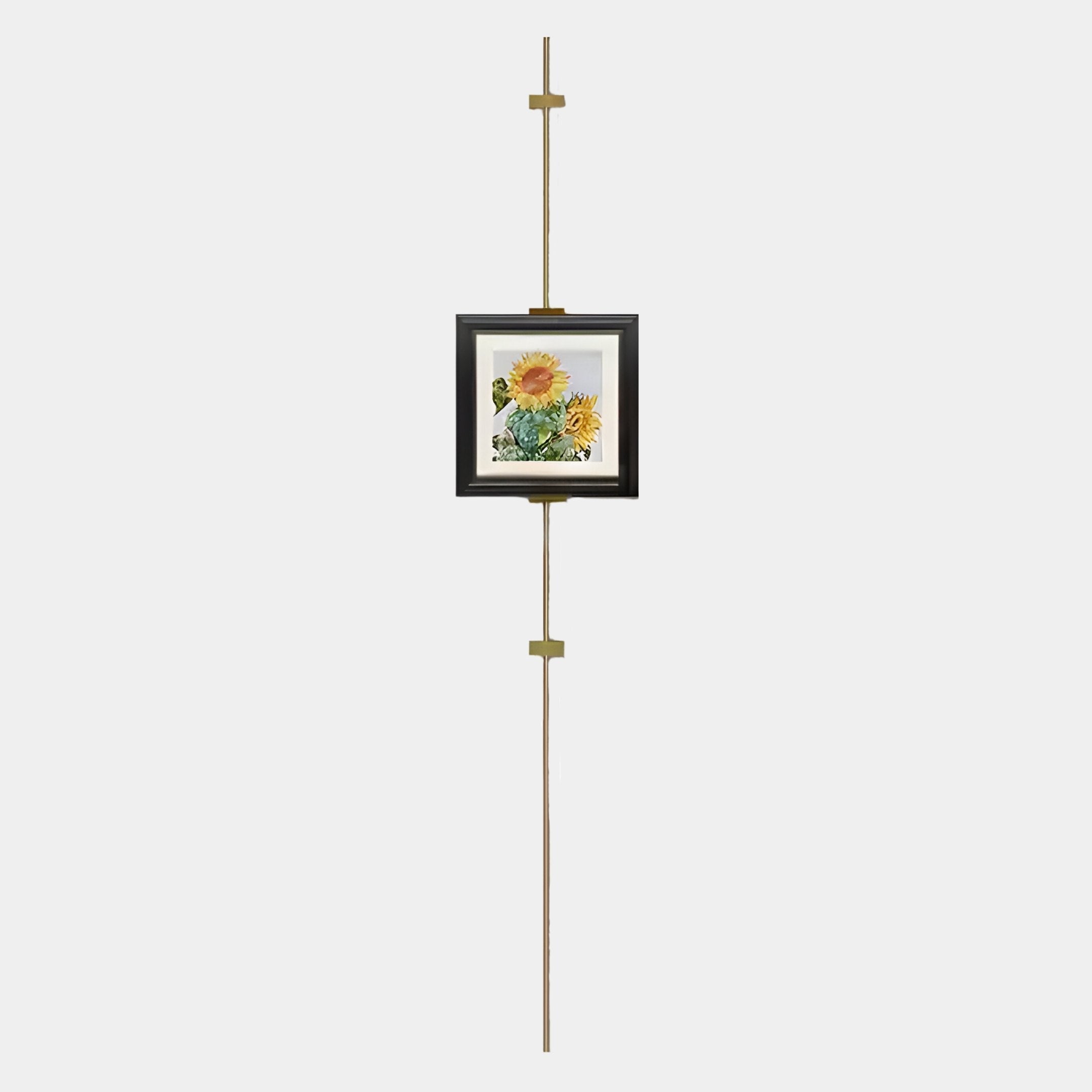 The Ecliptica Sunflower Botanical Illustration Gold Frame Wall Art by Giant Sculptures hangs on a brass rod with adjustable brackets, bringing botanical charm and modern style to any space against a clean white background.