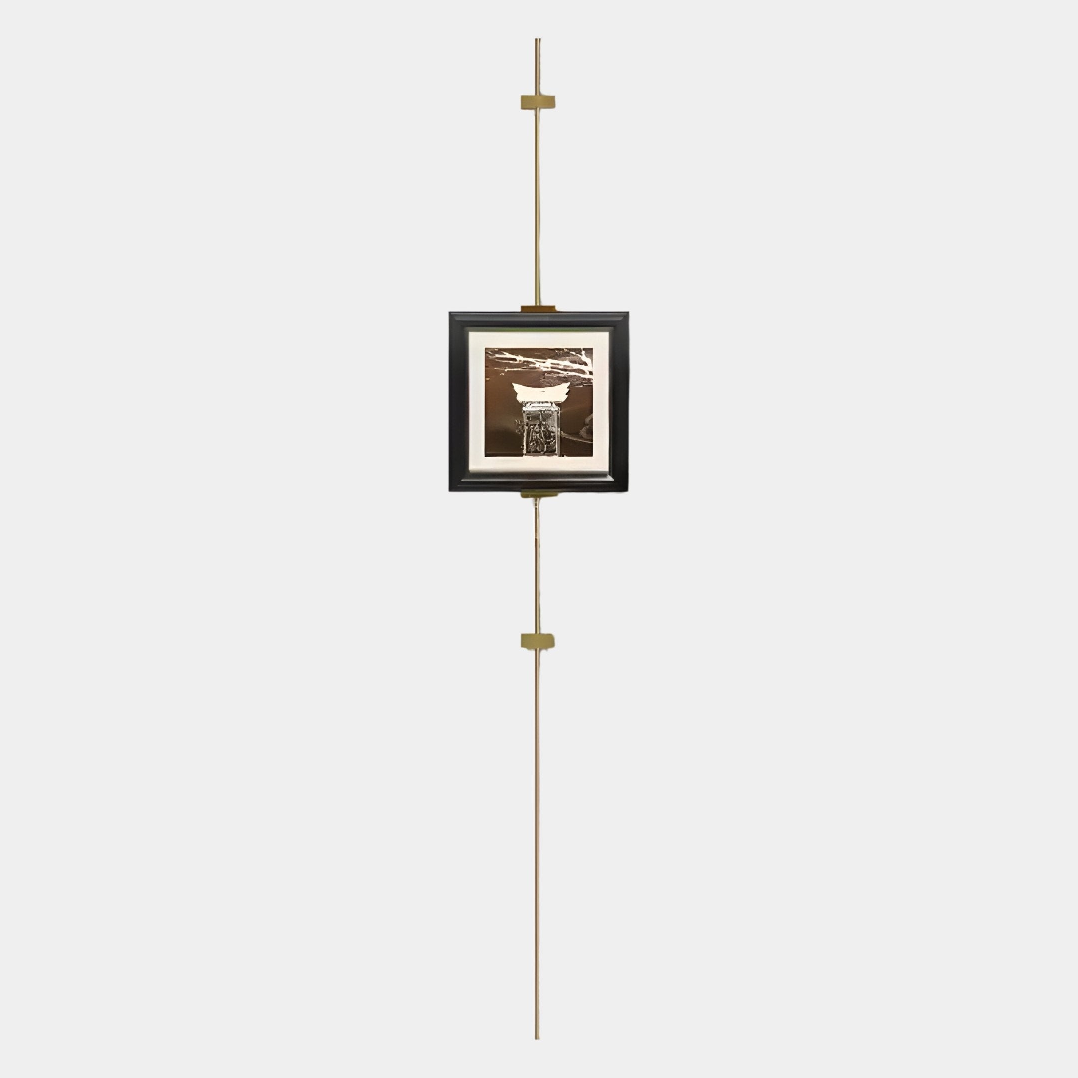 The Ecliptica Abstract Architectural Column Gold Frame Wall Art by Giant Sculptures features a framed abstract column suspended on a slim vertical brass rod with horizontal brackets, showcasing modern design against a plain white background.