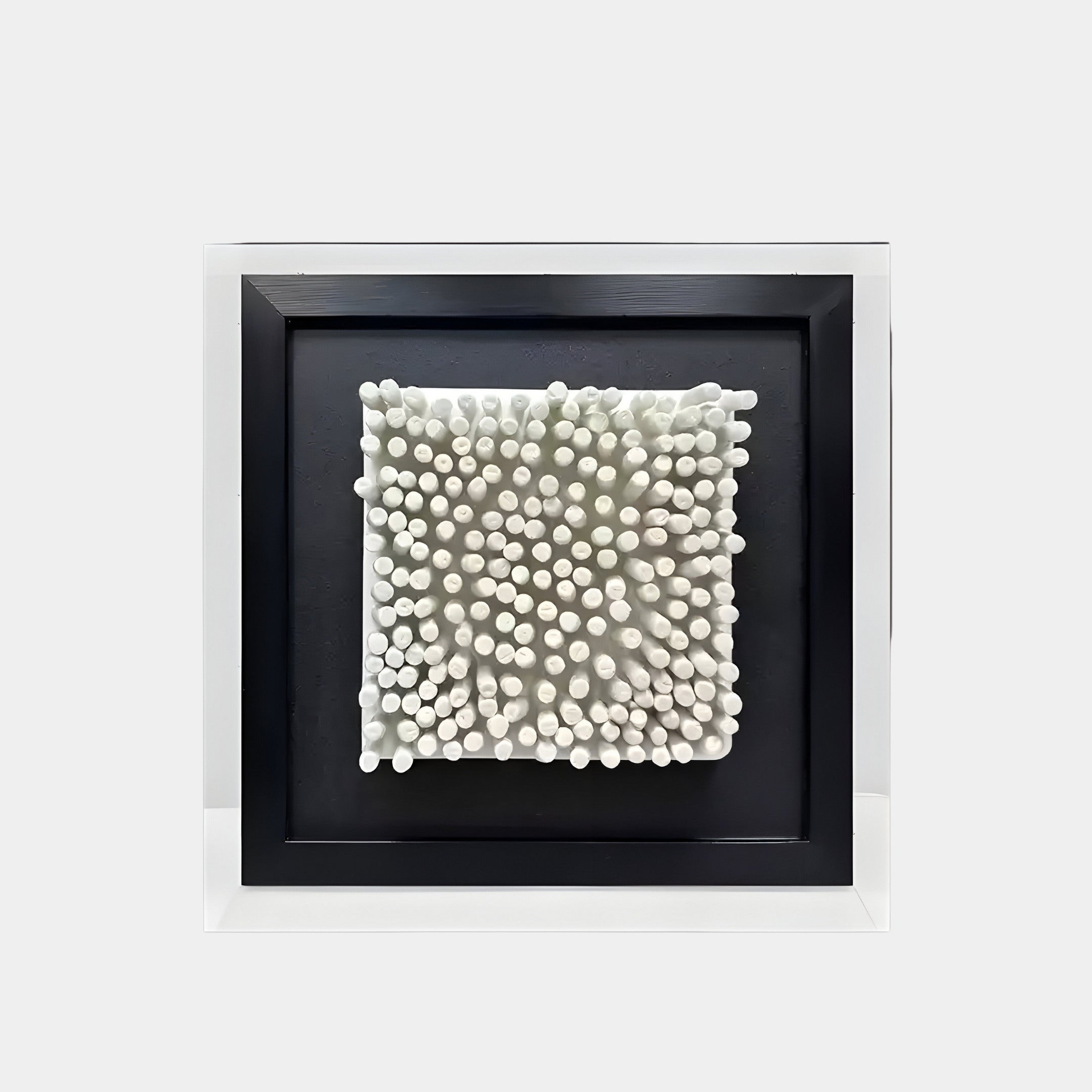 The Harmonia Elegant 3D Ceramic Grid by Giant Sculptures showcases a square design with white cylindrical rods on a black frame, creating a textured pattern. Ideal for modern minimalist décor, this piece elevates any plain white wall with its sculptural depth.