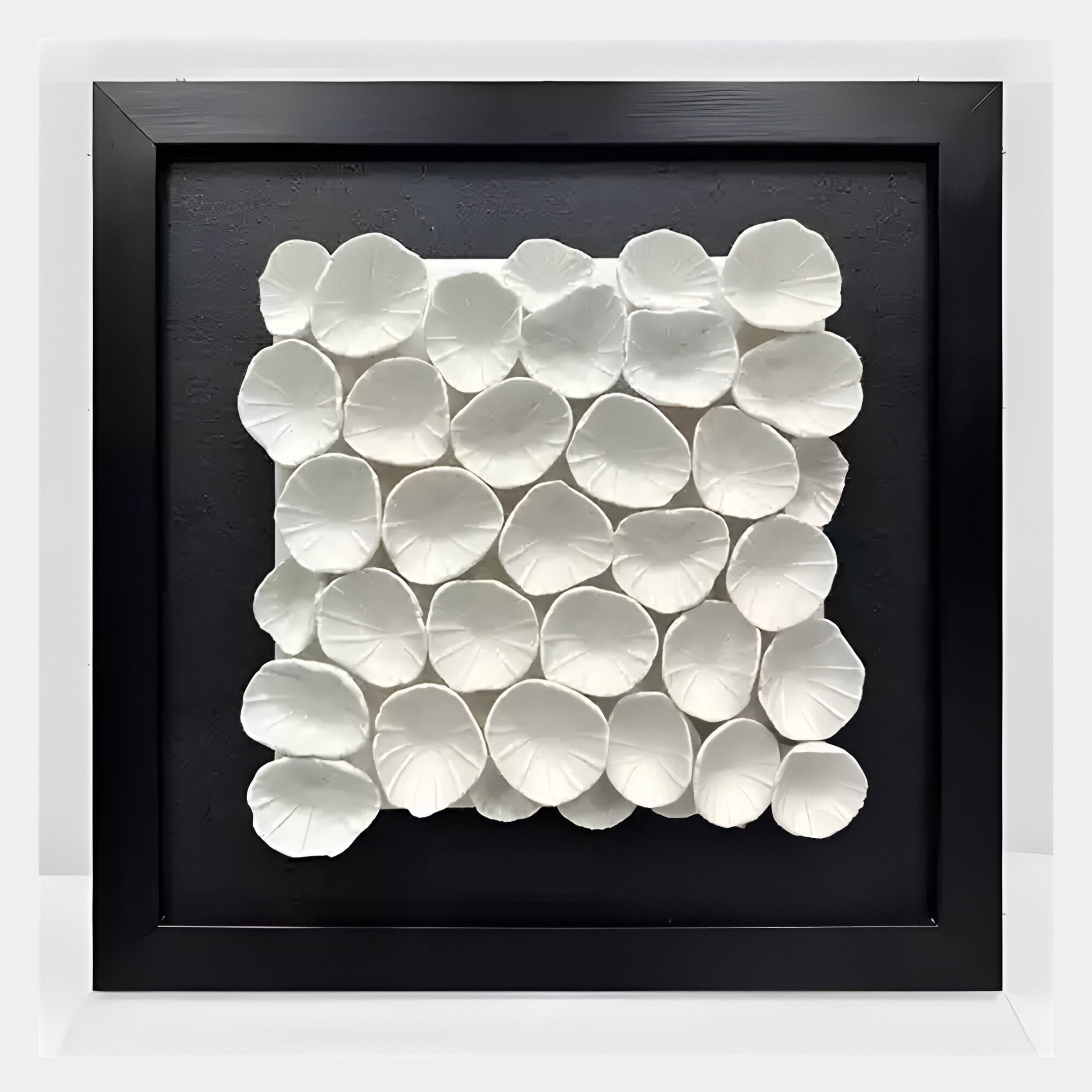 The Harmonia 3D Ceramic Petal Wall Sculpture by Giant Sculptures features white petal-like forms in a black frame and acrylic box, offering organic elegance and a striking modern look.