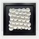 The Harmonia 3D Ceramic Petal Wall Sculpture by Giant Sculptures features white petal-like forms in a black frame and acrylic box, offering organic elegance and a striking modern look.