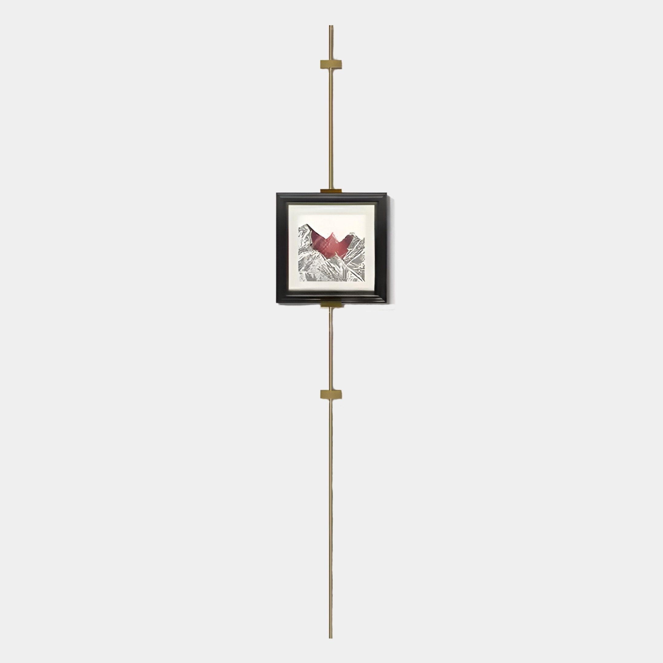 The Ecliptica Red Mountain Abstract Gold Frame Wall Art by Giant Sculptures features a red heart and black lines, suspended on a minimalist gold rod, creating striking contemporary decor against a plain white backdrop.